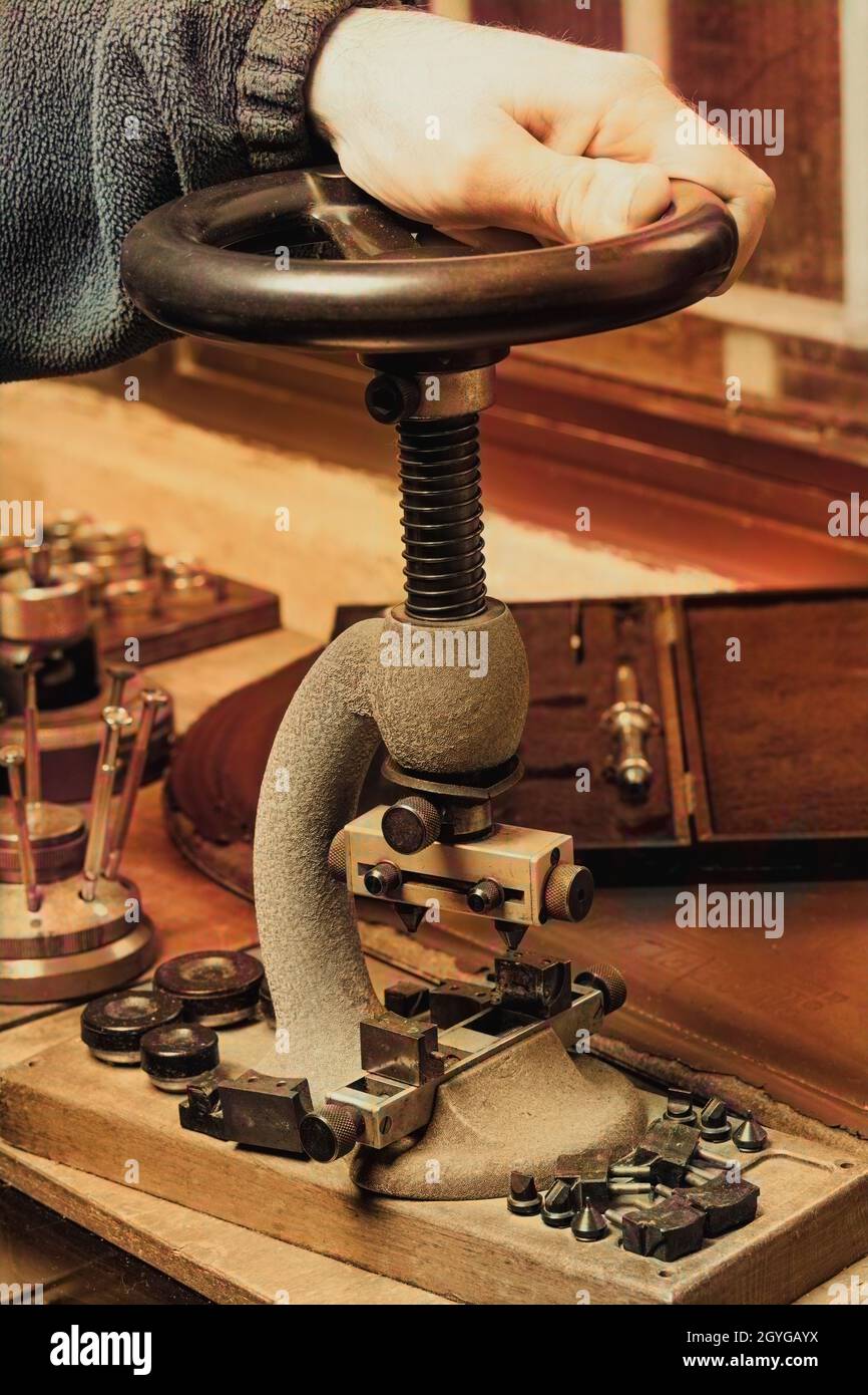 Mano maschio appoggiata su una pressa da banco rotante vintage su un banco  da lavoro con un assortimento di accessori e utensili sulla superficie in  legno Foto stock - Alamy