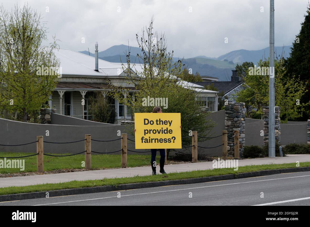 Un protesto anti-vaccinazione blocca un segnale chiedendo se i media forniscono equità durante una protesta in Nuova Zelanda Foto Stock