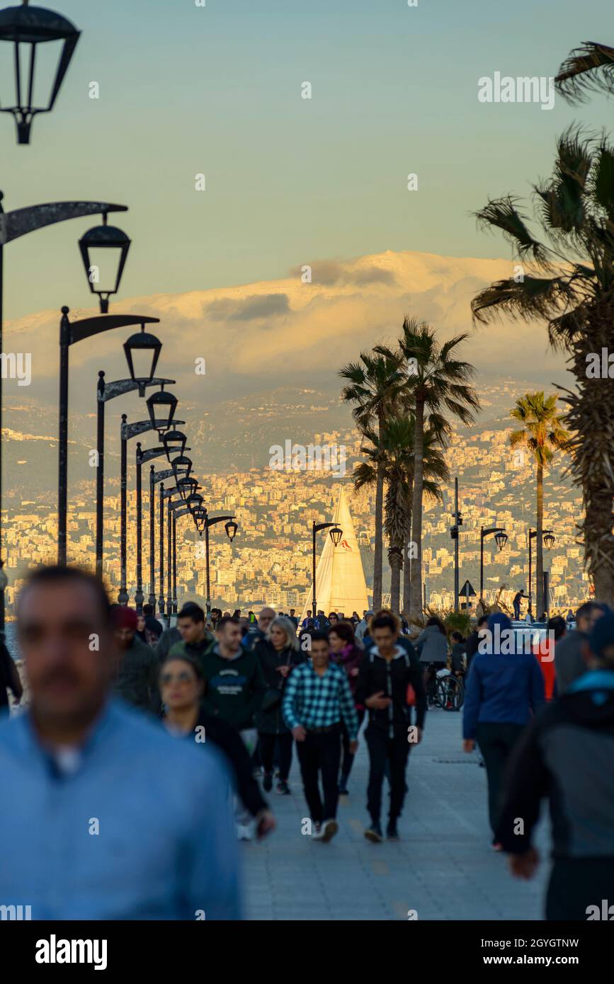 LIBANO, BEIRUT, DAR MREISSE, BEIRUT CORNICHE A FINE GIORNATA E IL MONTE SANNINE SOTTO LA NEVE IN INVERNO Foto Stock