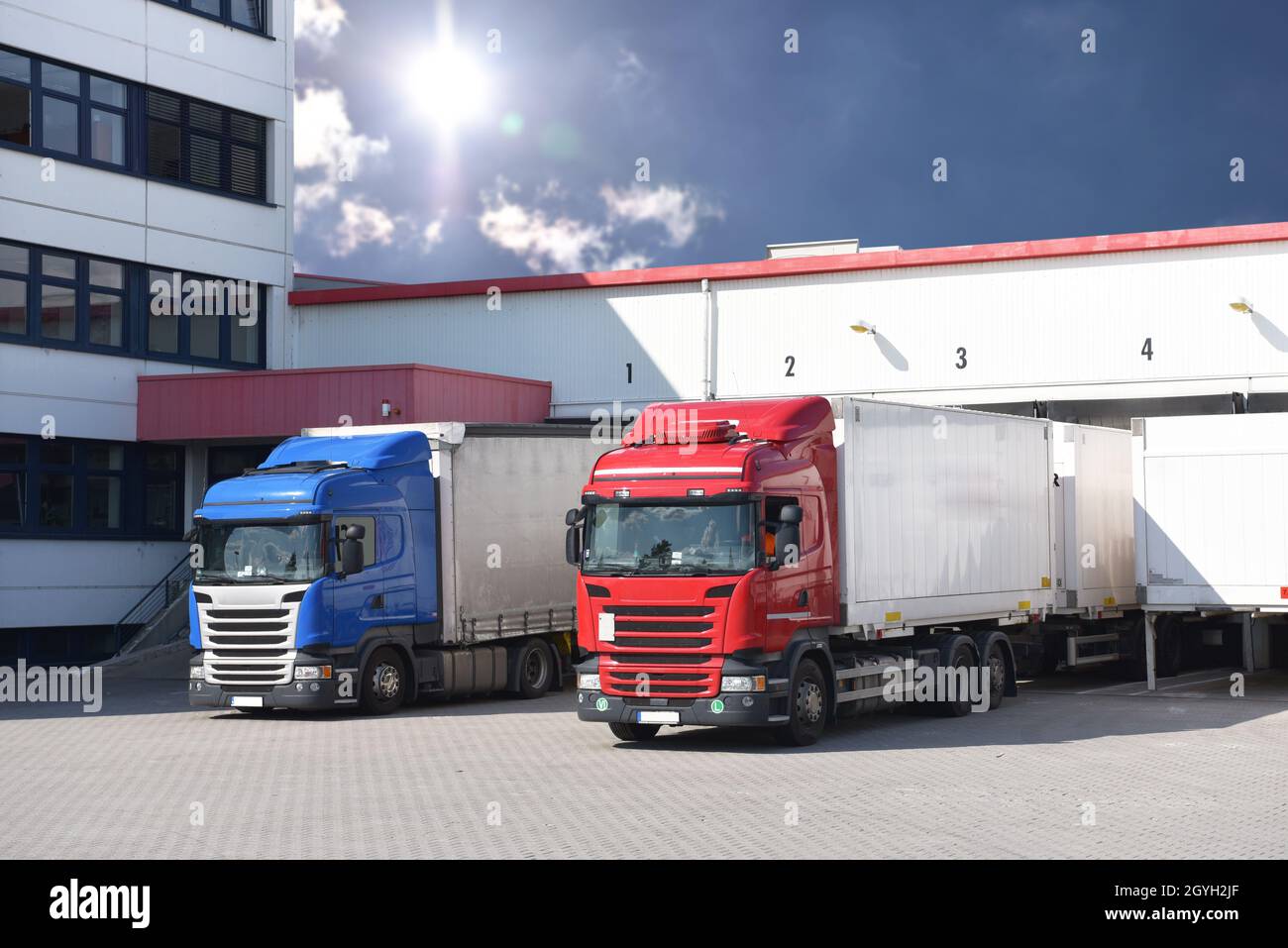 Camion che caricano ad un deposito di un'agenzia di spedizione - Trasporti e logistica nel commercio di merci Foto Stock