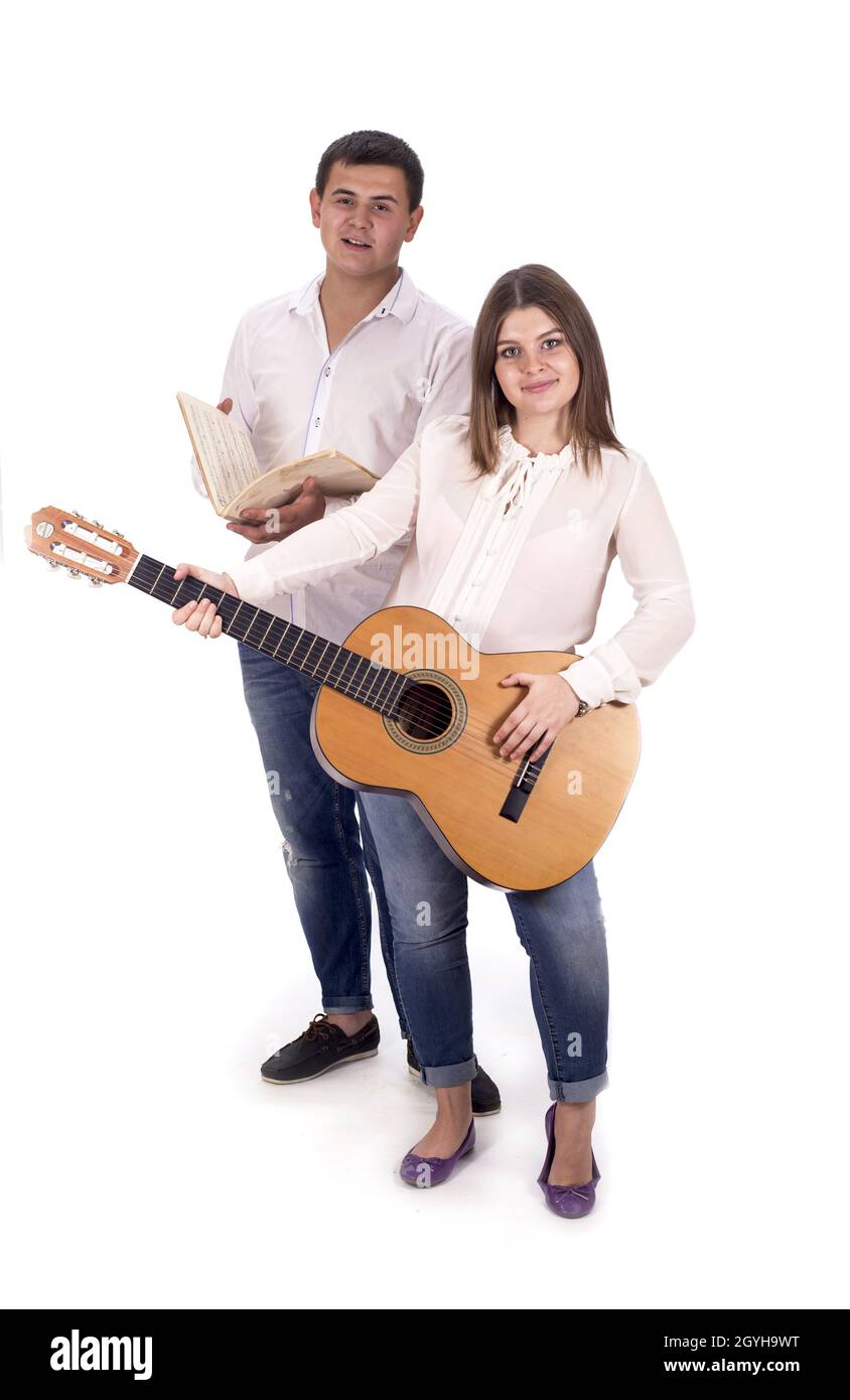 persone e musica. Donna e uomo incinta in camicie bianche e jeans con chitarra su sfondo bianco Foto Stock