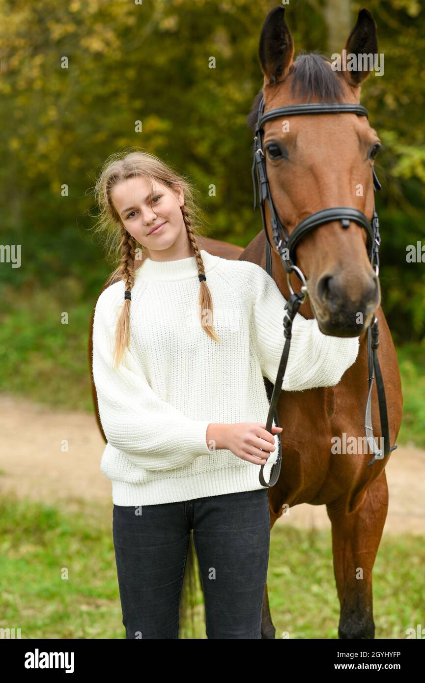 Giovane ragazza che cammina con un cavallo in natura Foto stock - Alamy