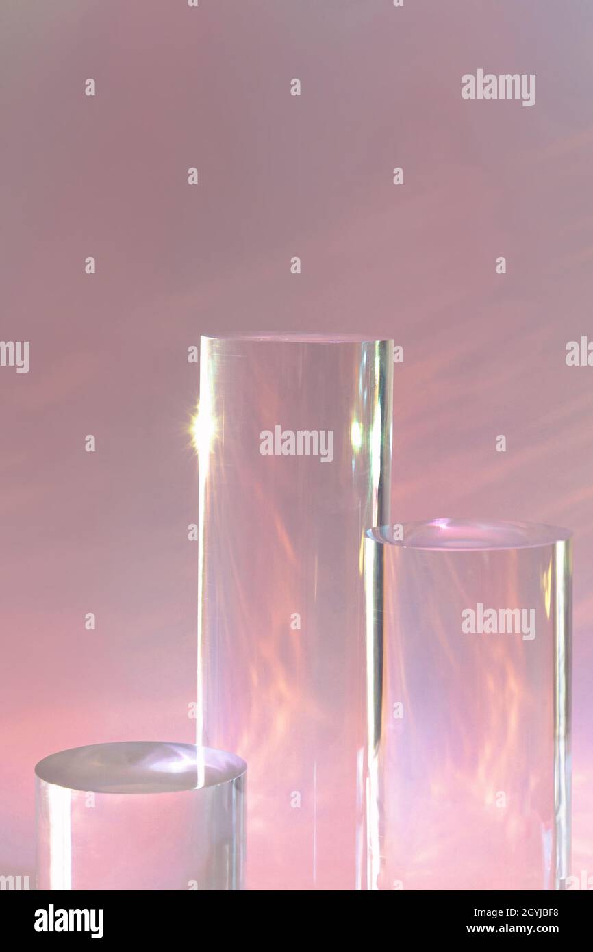 tre podi in vetro chiaro su sfondo rosa pastello Foto Stock