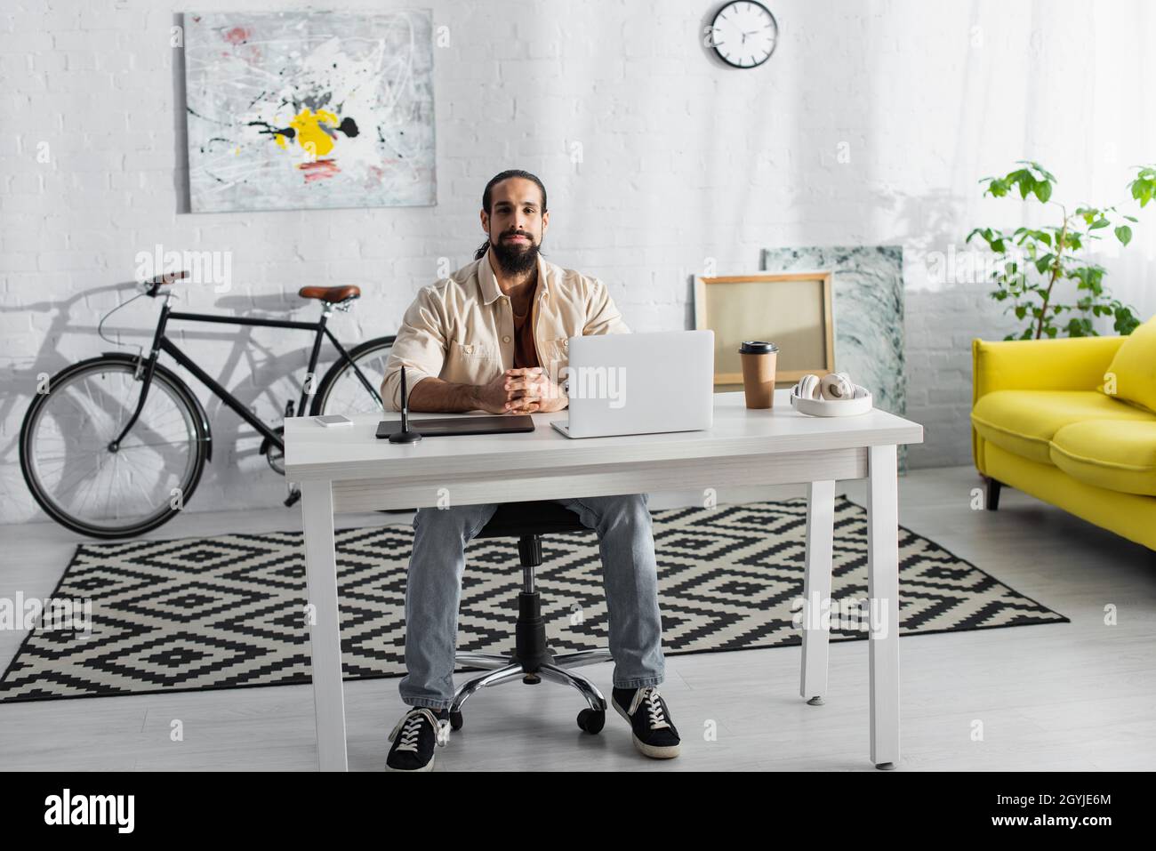 barbuto freelancer ispanico seduto sul posto di lavoro in casa studio Foto Stock
