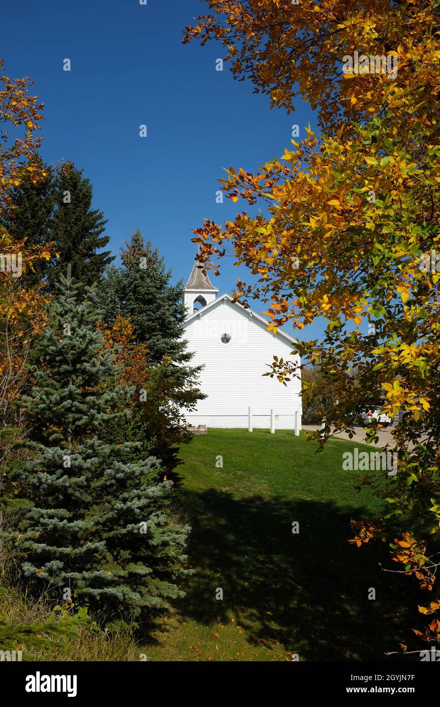JAMESTOWN, NORTH DAKOTA - 3 Oct 2021: Pioner Chiesa incorniciata da alberi in colori autunnali nella città di Frontier. Foto Stock JAMESTOWN, NORTH DAKOTA - 3 Oct 2021: Pioner Chiesa incorniciata da alberi in colori autunnali nella città di Frontier. Foto Stock