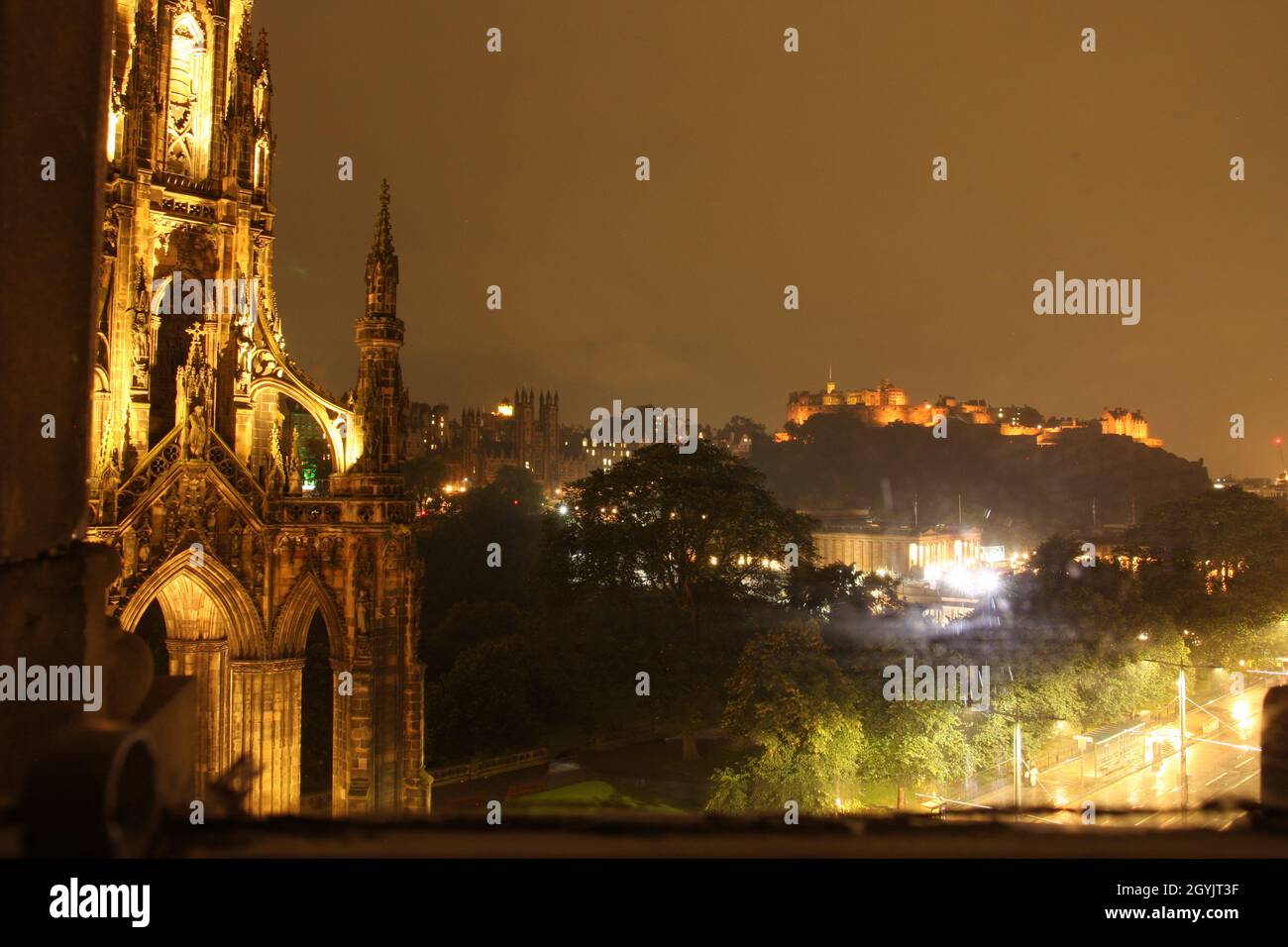 Edimburgo, Scozia di notte: Castello illuminato e Scott Memorial in primo piano Foto Stock