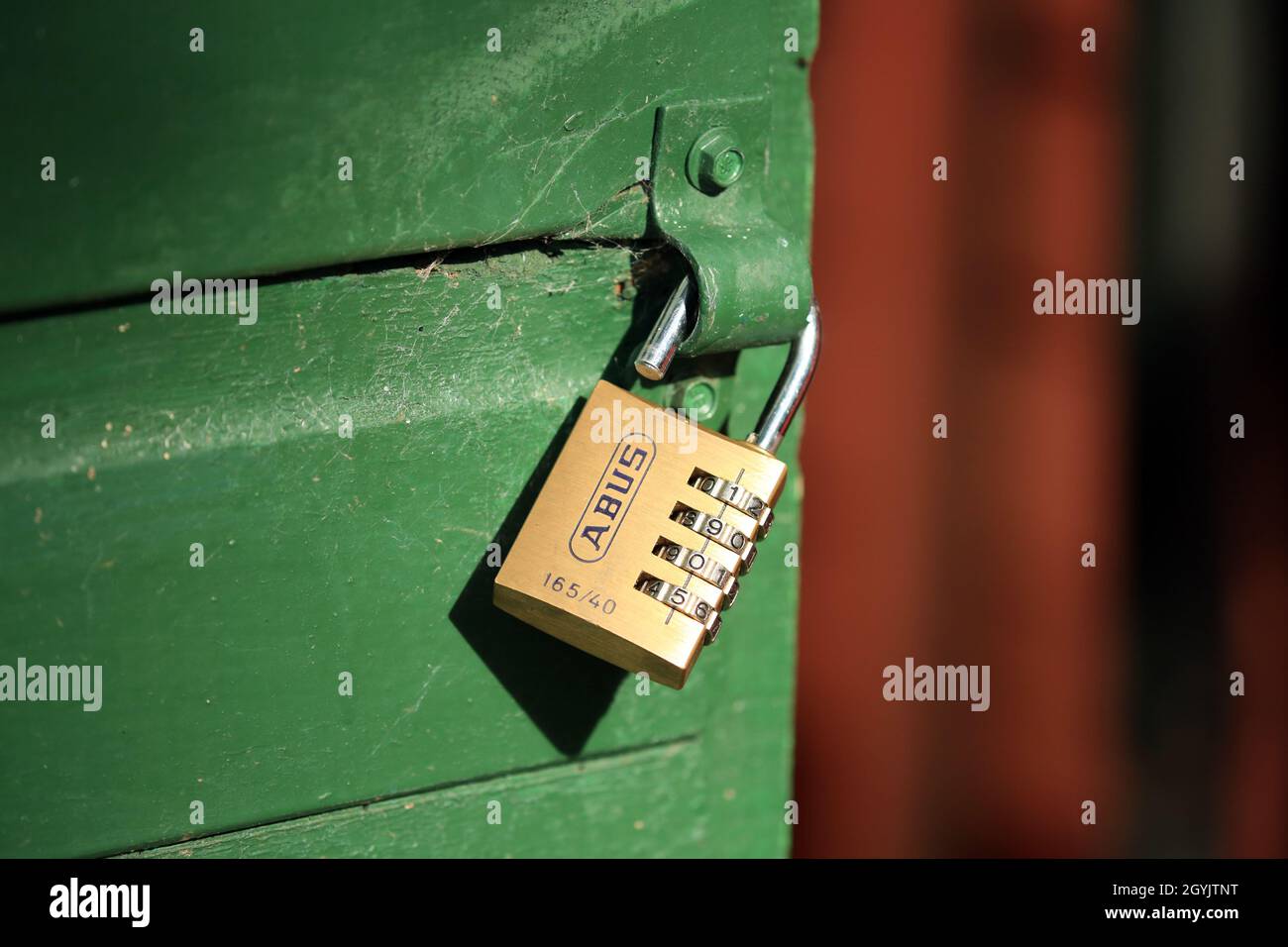 Un lucchetto a combinazione aperto su una porta capannone. Foto Stock
