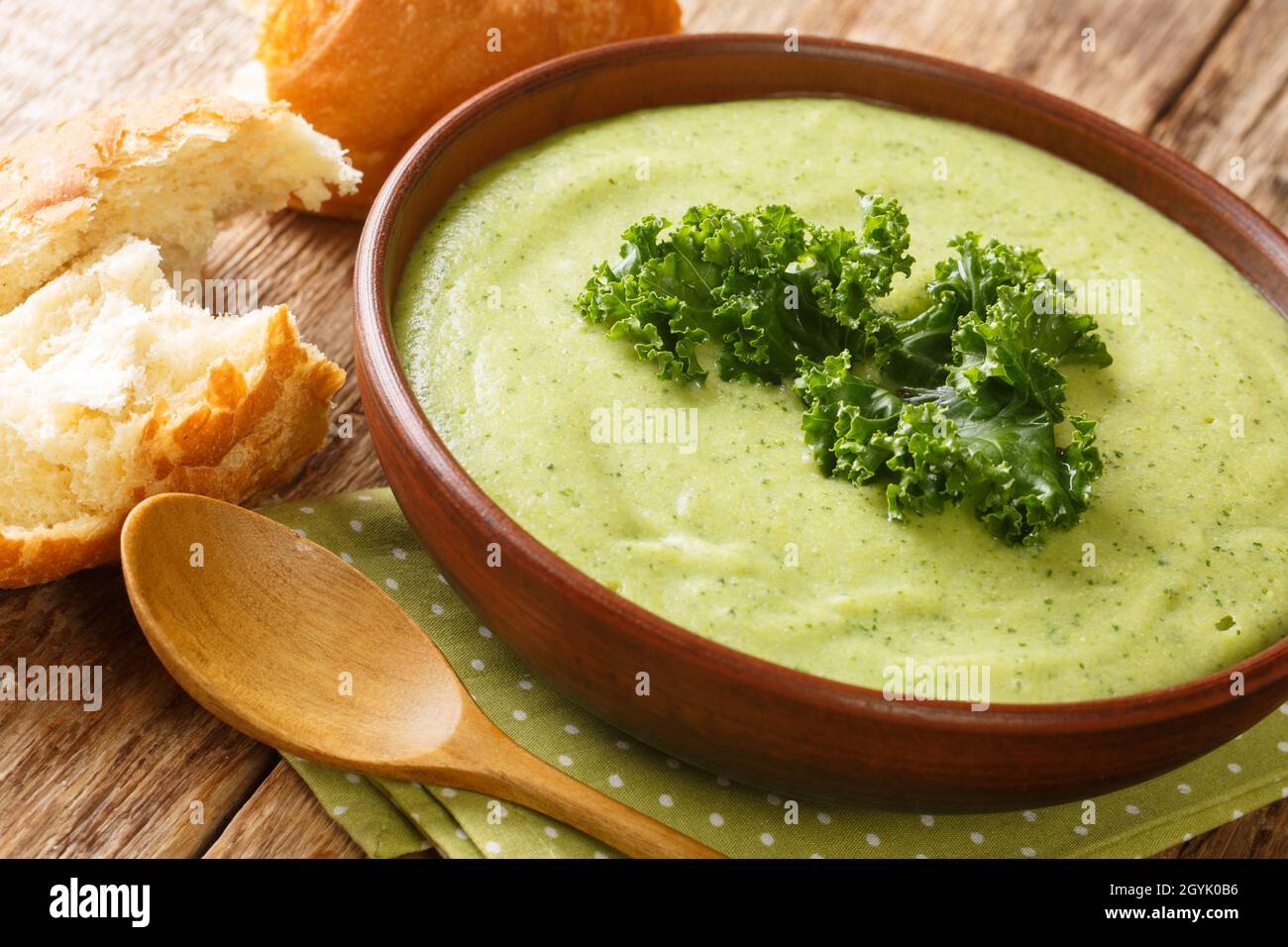Zuppa di panna verde vegetariana a base di cavolo kale da vicino in una ciotola sul tavolo. Orizzontale Foto Stock