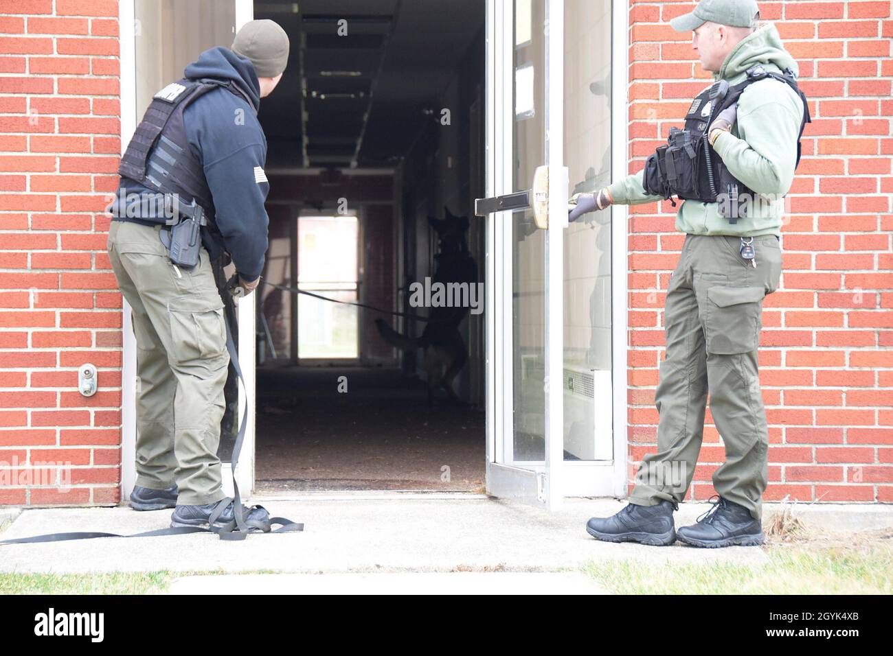 Trooper Adam McKenzie, Ohio state Highway Patrol Special Response Team K9 Handler, rilascia il suo partner canino in un edificio per cercare un sospetto durante un esercizio di formazione il 13 gennaio 2020 alla base della Guardia Nazionale aerea di Springfield, Ohio. La 178a ala ha fornito spazio per la formazione per facilitare la necessità di varietà negli ambienti di formazione. (Air National Guard Photo di Capt. Lou Burton) Foto Stock