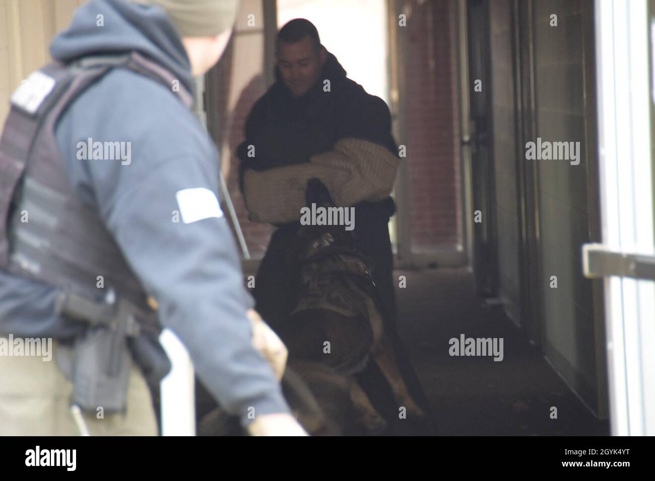 Trooper Adam McKenzie, Ohio state Highway Patrol Special Response Team K9 Handler, guarda mentre il suo partner canino ingaggia il sospetto durante un esercizio di formazione il 13 gennaio 2020 alla base della Guardia Nazionale aerea di Springfield, Ohio. La 178a ala ha fornito spazio per la formazione per facilitare la necessità di varietà negli ambienti di formazione. (Air National Guard Photo di Capt. Lou Burton) Foto Stock