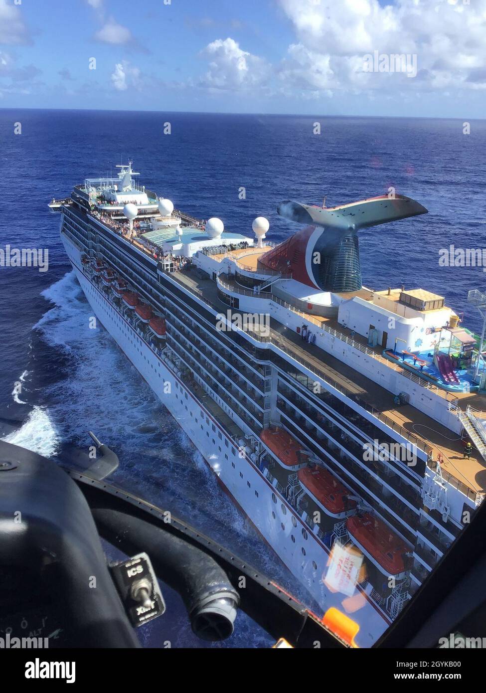 Una guardia costiera Stazione aria Borinquen MH-65 Dolphin equipaggio elicottero sorvola la nave da crociera Carnival Pride, circa 75 miglia a nord di San Juan, Puerto Rico, gen. 16, 2020. Il Coast Guard medevaced un 34-anno-vecchio uomo dalla nave da crociera Carnival Pride, circa 75 miglia a nord di San Juan. (Coast Guard foto) Foto Stock