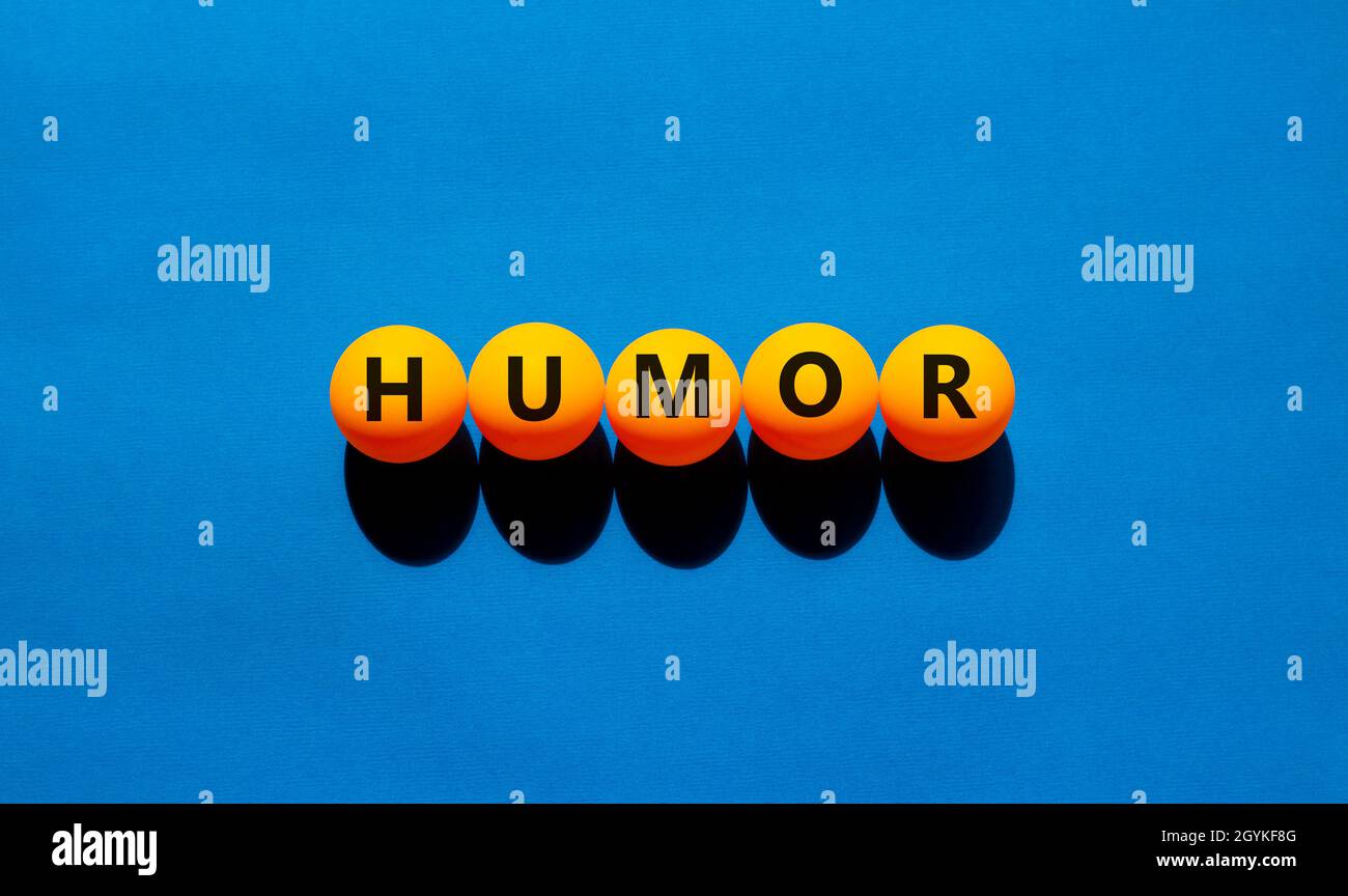 Simbolo dell'umorismo. La parola di concetto 'humour' sulle palle da tennis da tavolo arancioni. Bella tabella blu, sfondo blu, spazio copia. Business, psicologico e hu Foto Stock