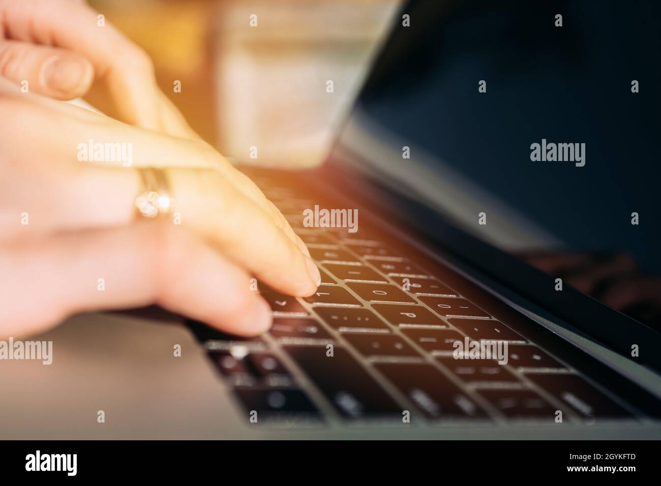 Donna che lavora al computer portatile mentre si siede in panchina nel parco autunnale. Foto Stock