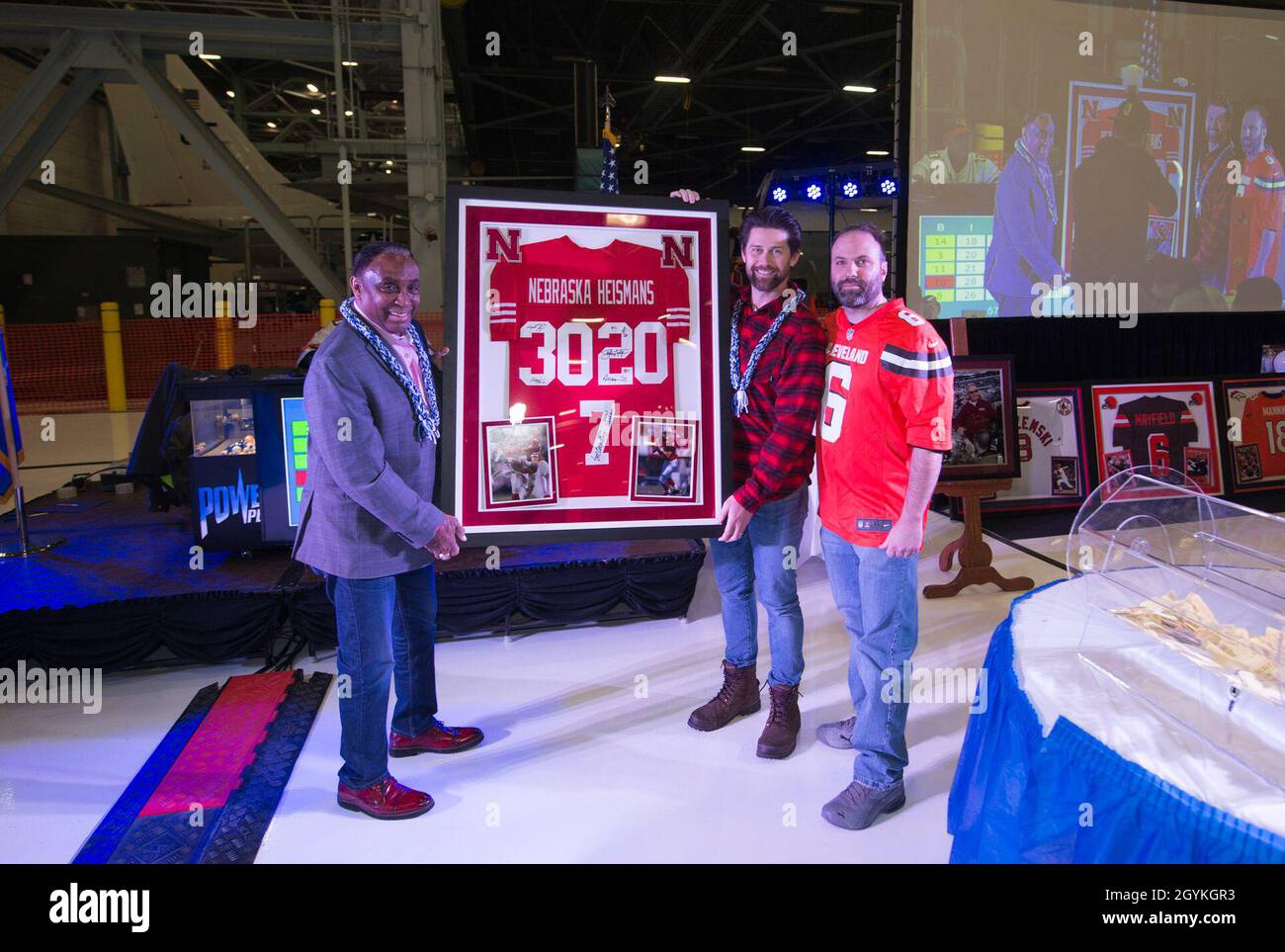Darryl Ebsch, un sergente del Maestro dell'aeronautica degli Stati Uniti in pensione, si pone con Johnny Rogers (a sinistra) ed Eric Crouch, Chi sono i vincitori del Trofeo Heisman dell'Università del Nebraska durante l'evento annuale di cimeli del Super Saturday che si tiene nel Dock 2 del Bennie L. Davis Maintenance Facility, 18 gennaio 2020, sulla base dell'aeronautica militare Offutt, Nebraska. I due vincitori di Heisman hanno partecipato all'evento per firmare autografi per i fan e presentare la maglia incorniciata raffigurante tutti e tre i vincitori di Heisman del Nebraska. (STATI UNITI Air Force foto di Josh Plueger) Foto Stock