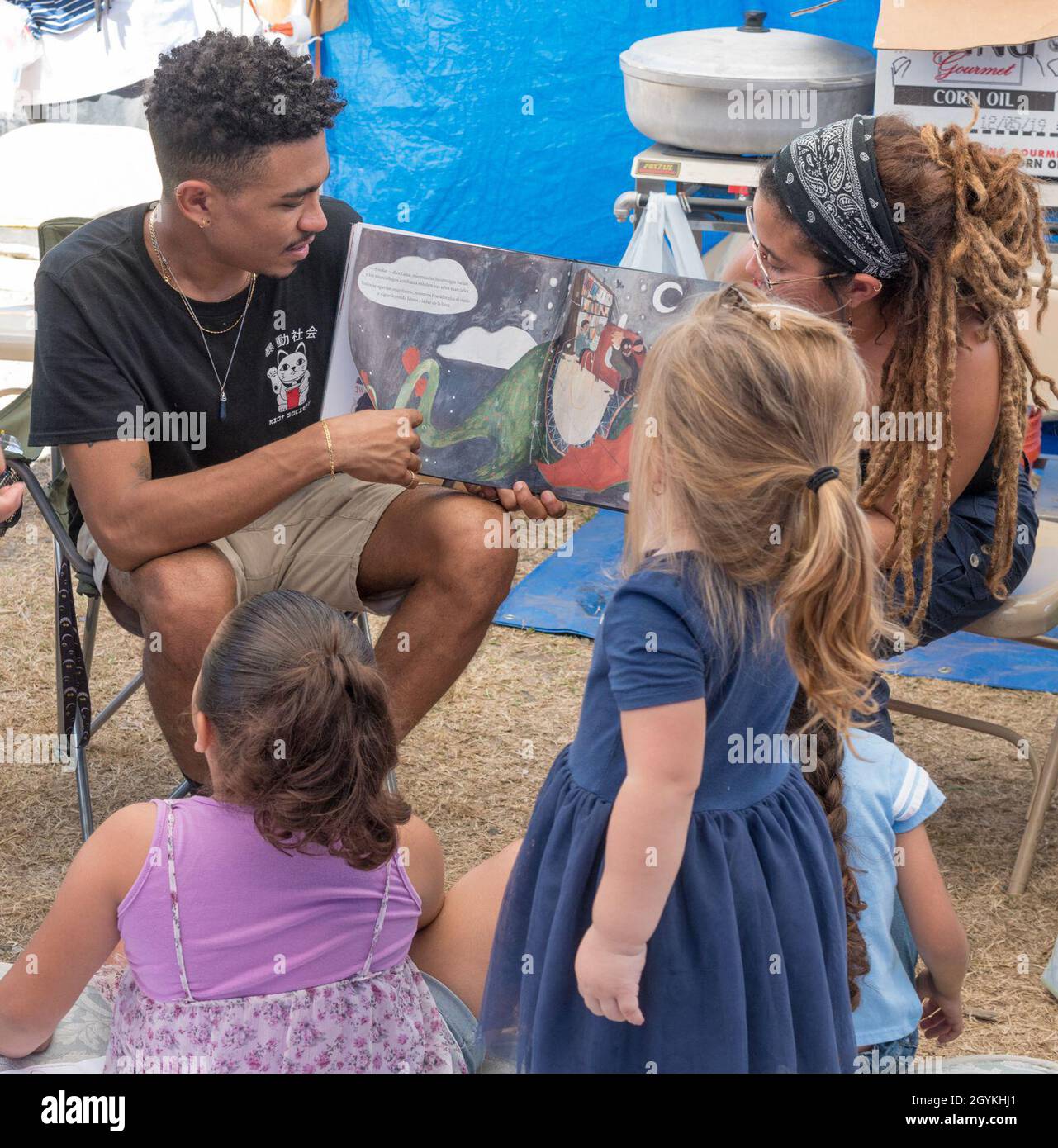 Guaynilla, PR, 19 gennaio 2020 -- i volontari leggono ai bambini in un campo di comunità istituito per i sopravvissuti al terremoto. Le scosse di assestamento continuano a sconvolgere i residenti. Foto di Liz Roll/FEMA Foto Stock