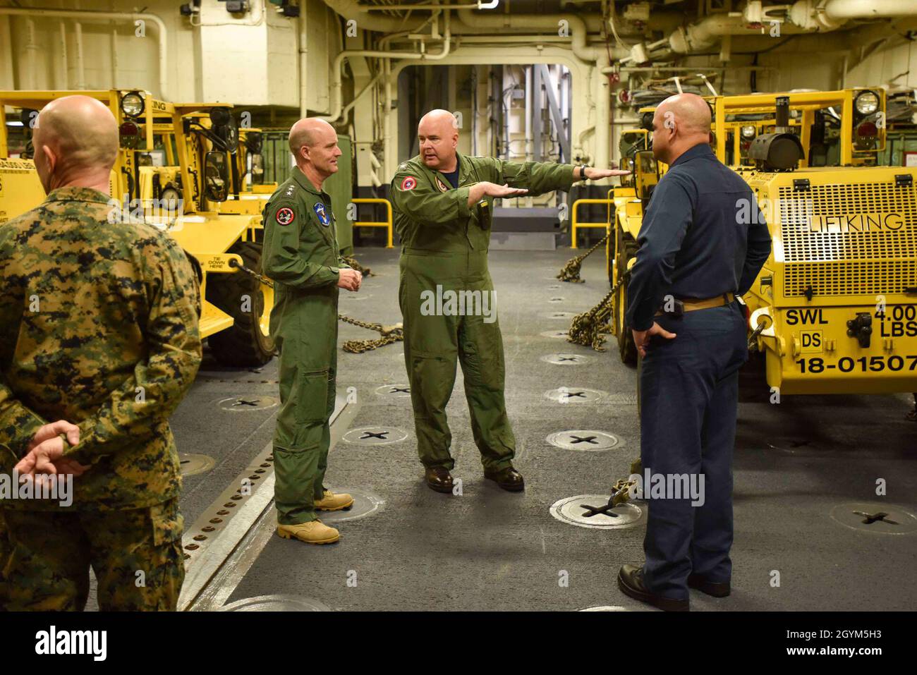 200129-N-MB038-1003 MAR DELLE FILIPPINE (GEN. 29, 2020) Vice ADM. Bill Merz, comandante, US 7a flotta, a sinistra, fa un tour dell'area di stoccaggio del veicolo della nave d'assalto anfibio USS America (LHA 6). L'America, ammiraglia dell'America Expeditionary Strike Group, 31st Marine Expeditionary Unit team, opera nell'area operativa della 7a flotta statunitense per migliorare l'interoperabilità con alleati e partner e fungere da forza di reazione pronta a difendere la pace e la stabilità nella regione IndoPacifico. (STATI UNITI Foto Navy di Mass Communication Specialist 2a classe Christopher Marshall) Foto Stock