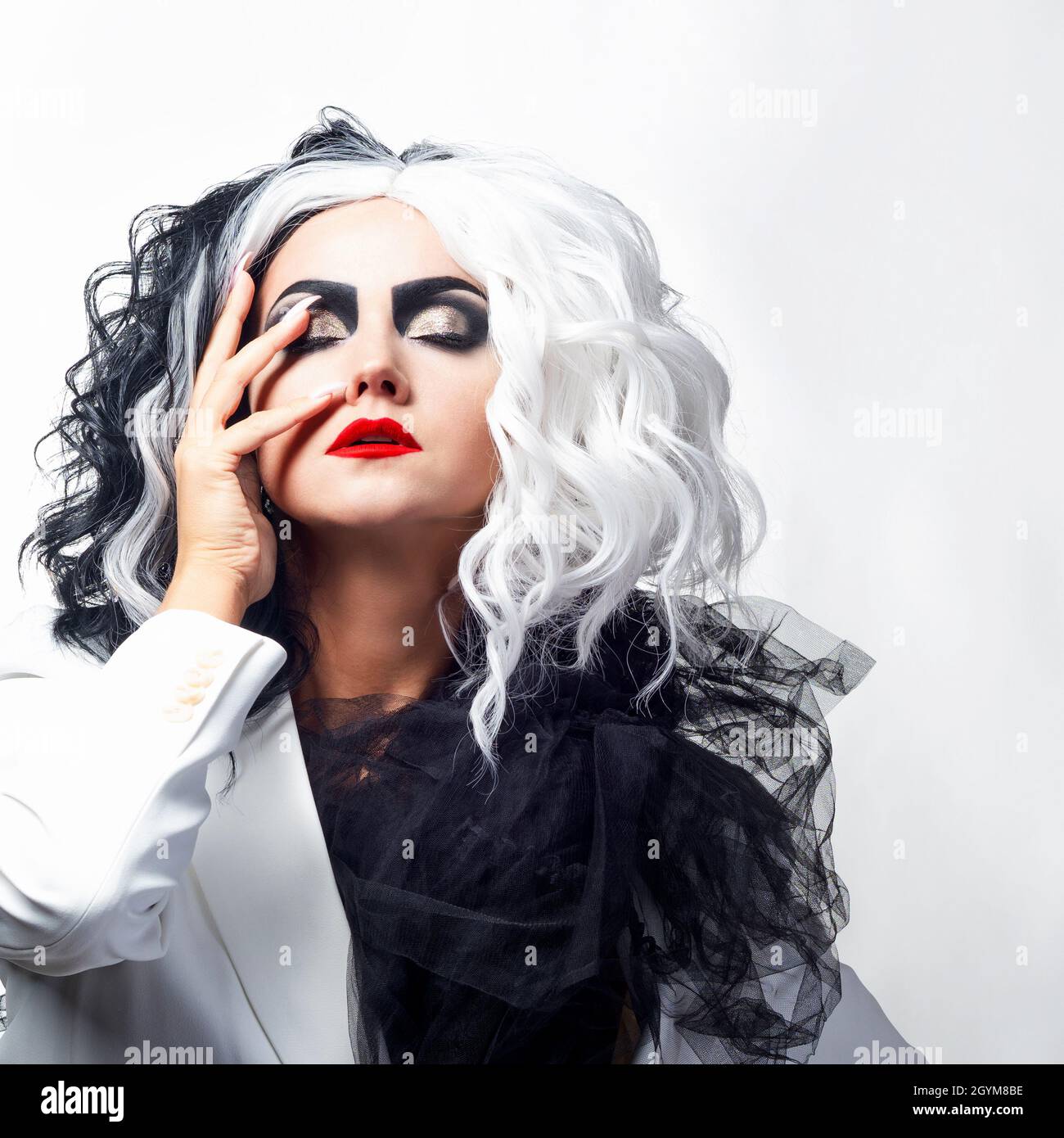 Una donna carismatica insolita in un abito bianco e nero con capelli bianchi  e neri, un'immagine audace ed elegante di un criminale per Halloween Foto  stock - Alamy