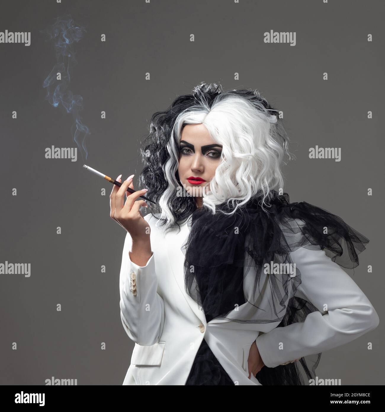 Una bellezza fatale in un'immagine di moda audace con capelli bianchi e neri. Un'immagine di stile ribelle per Halloween. Una giovane donna in un outfi bianco e nero Foto Stock