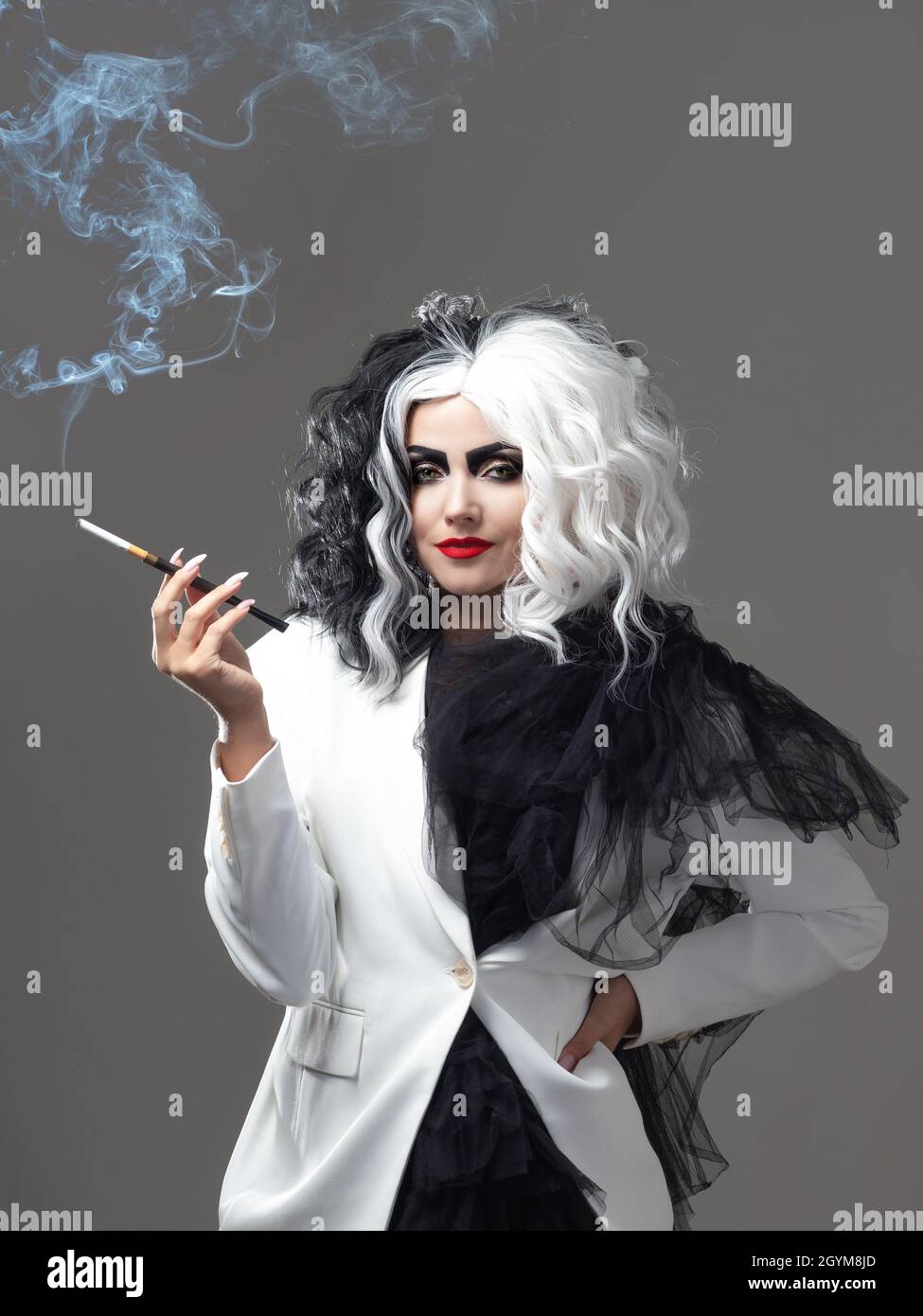 Una bellezza fatale in un'immagine di moda audace con capelli bianchi e neri. Un'immagine di stile ribelle per Halloween. Una giovane donna in un outfi bianco e nero Foto Stock