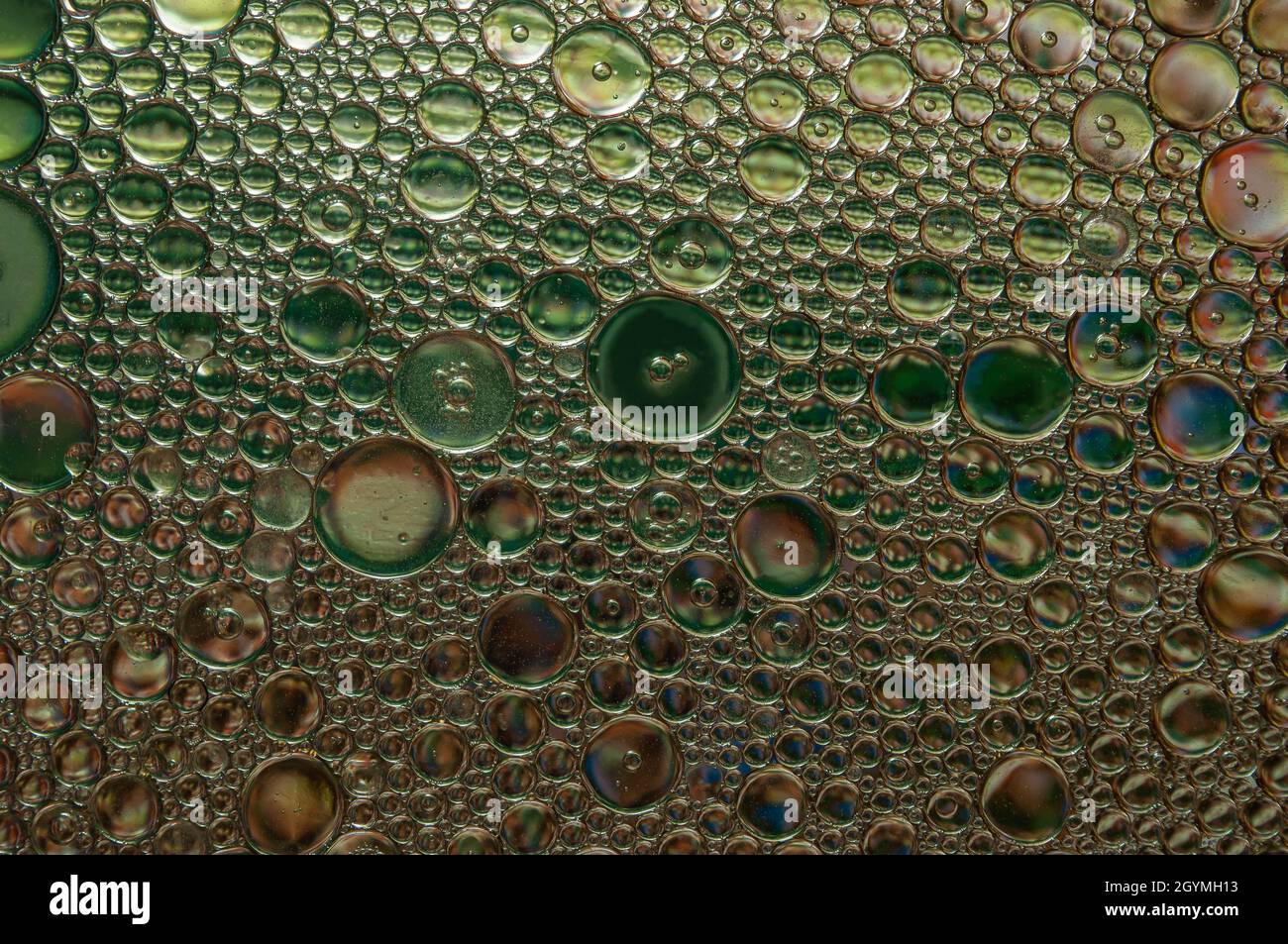 Sfondo astratto e consistenza di gocce d'olio su acqua con colori diversi Foto Stock