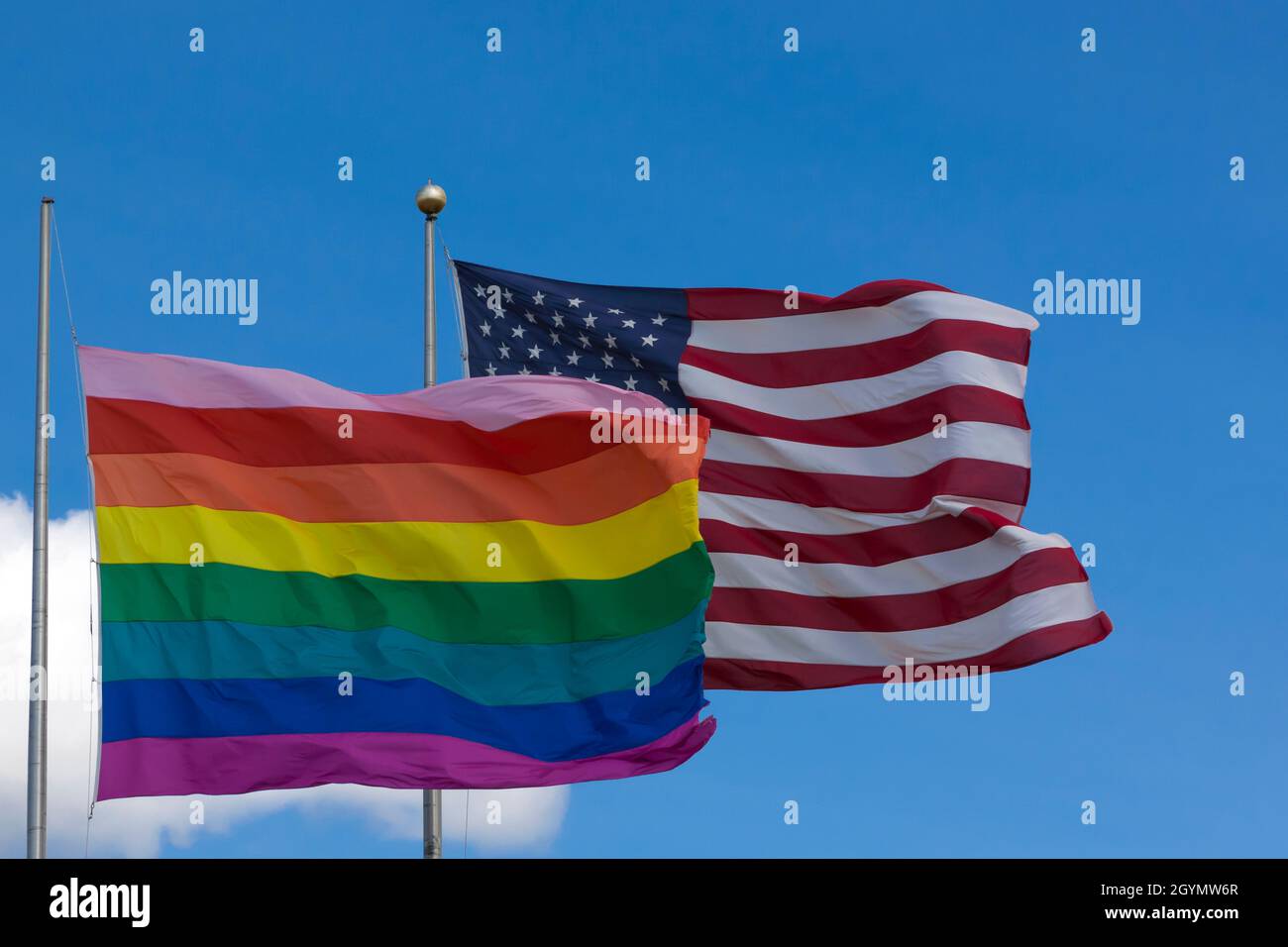 Bandiera arcobaleno/bandiera gay Pride (LGBT) che vola accanto alla bandiera americana su Cherry Grove, Fire Island, New York, Stati Uniti d'America. Foto Stock