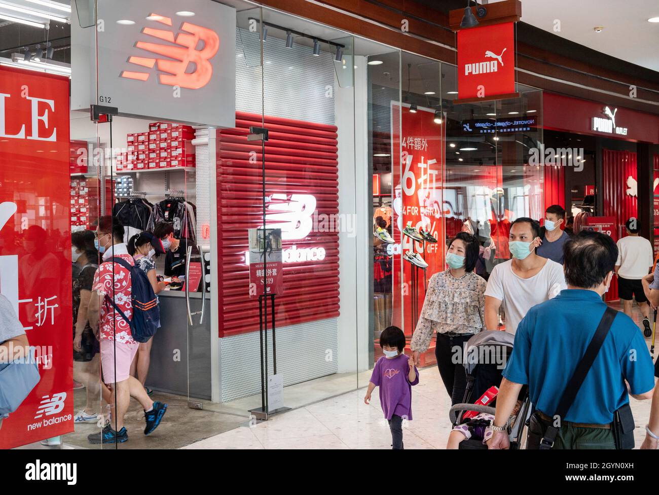 Hong Kong, Cina. 1 ottobre 2021. Gli amanti dello shopping passano davanti al marchio americano New Balance (NB) e alla multinazionale tedesca Puma, marchio di calzature sportive e casual, negozi e logo a Hong Kong. (Credit Image: © Budrul Chukrut/SOPA Images via ZUMA Press Wire) Foto Stock