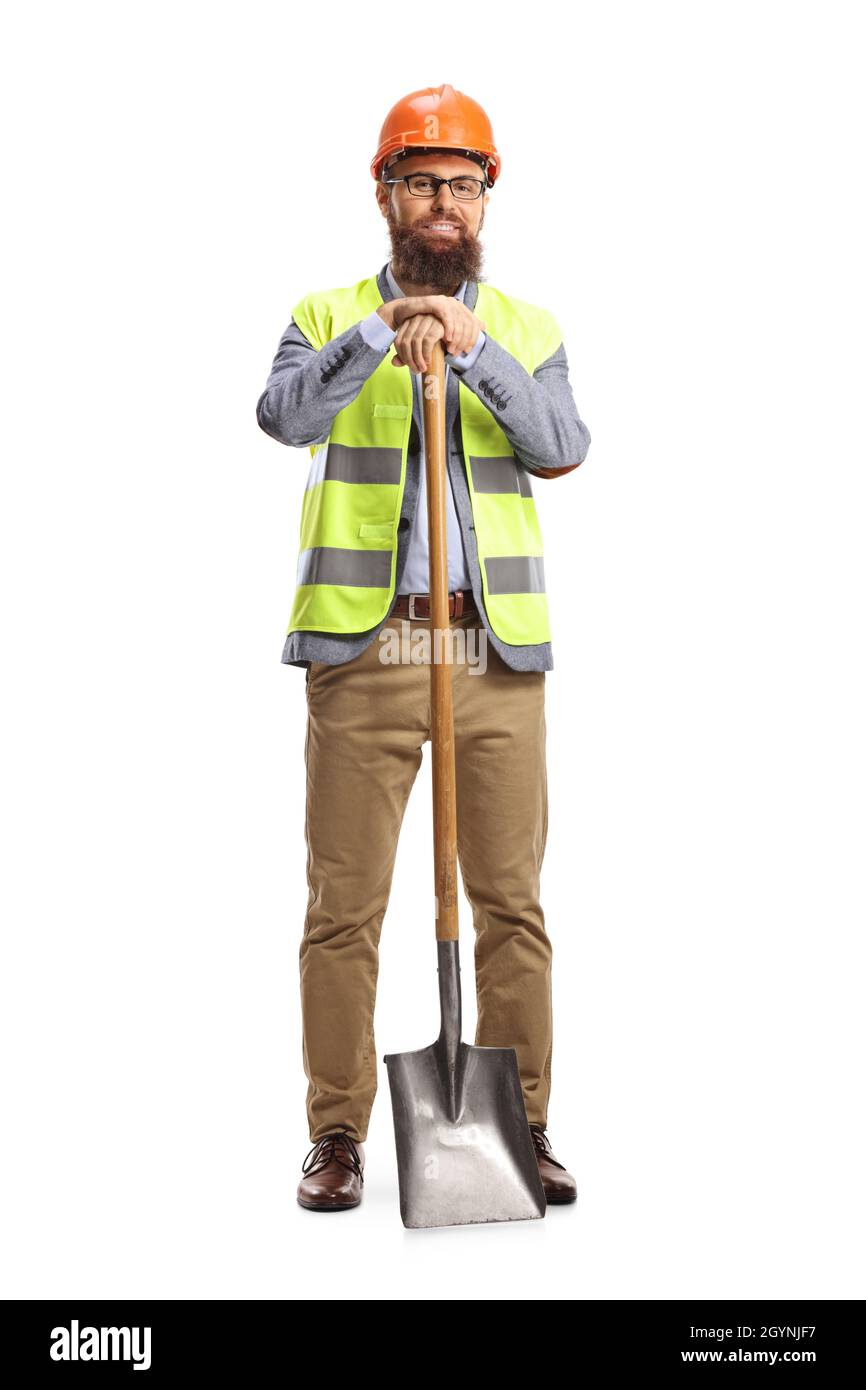 Ingegnere del sito con un gilet e un casco appoggiati su una pala isolata su sfondo bianco Foto Stock