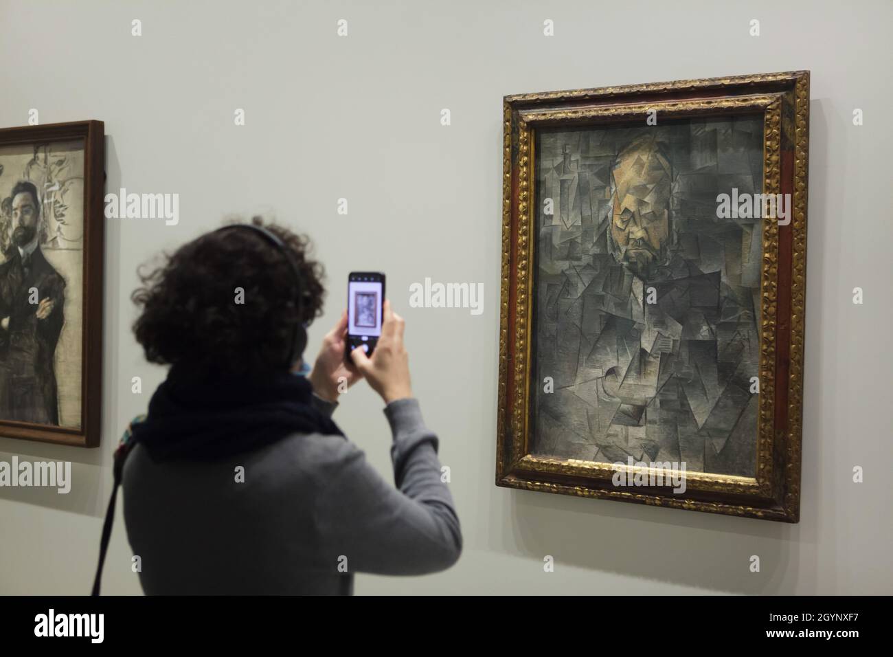 Il visitatore utilizza uno smartphone per fotografare il dipinto "Ritratto di Ambroise Vollard" di Pablo Picasso (1910) esposto alla mostra "icone di arte moderna della collezione Morozov" della Fondazione Louis Vuitton di Parigi, Francia. La mostra si svolge fino al 22 febbraio 2022. Foto Stock