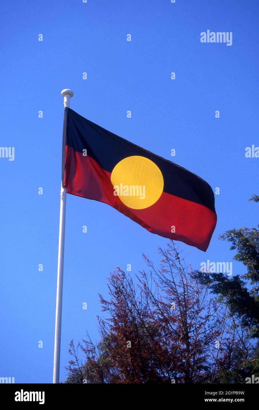 BANDIERA ABORIGINE CHE SVEGLIA NEL VENTO, CANBERRA, TERRITORIO DELLA CAPITALE AUSTRALIANA. Foto Stock
