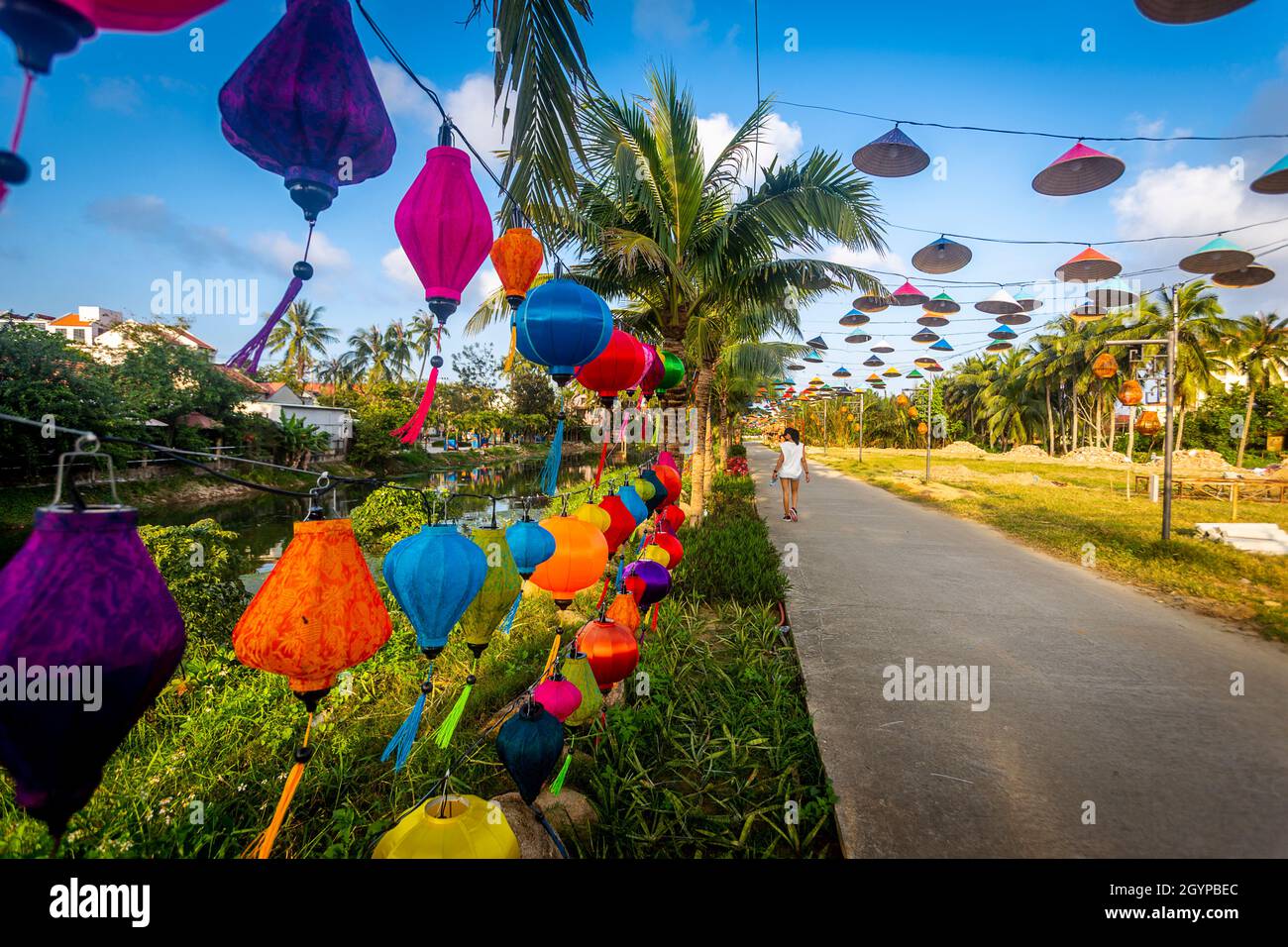 Donna che fa una passeggiata lungo una strada tranquilla a Hoi An. Foto Stock