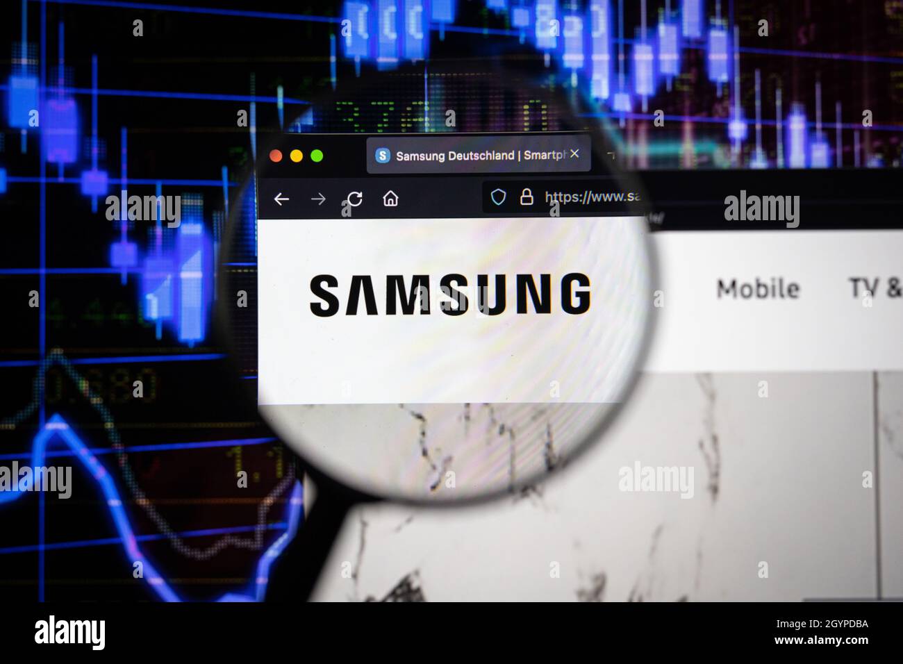 Samsung Company logo su un sito web con blurry mercato azionario sviluppi in background, visto su uno schermo di computer attraverso una lente d'ingrandimento Foto Stock