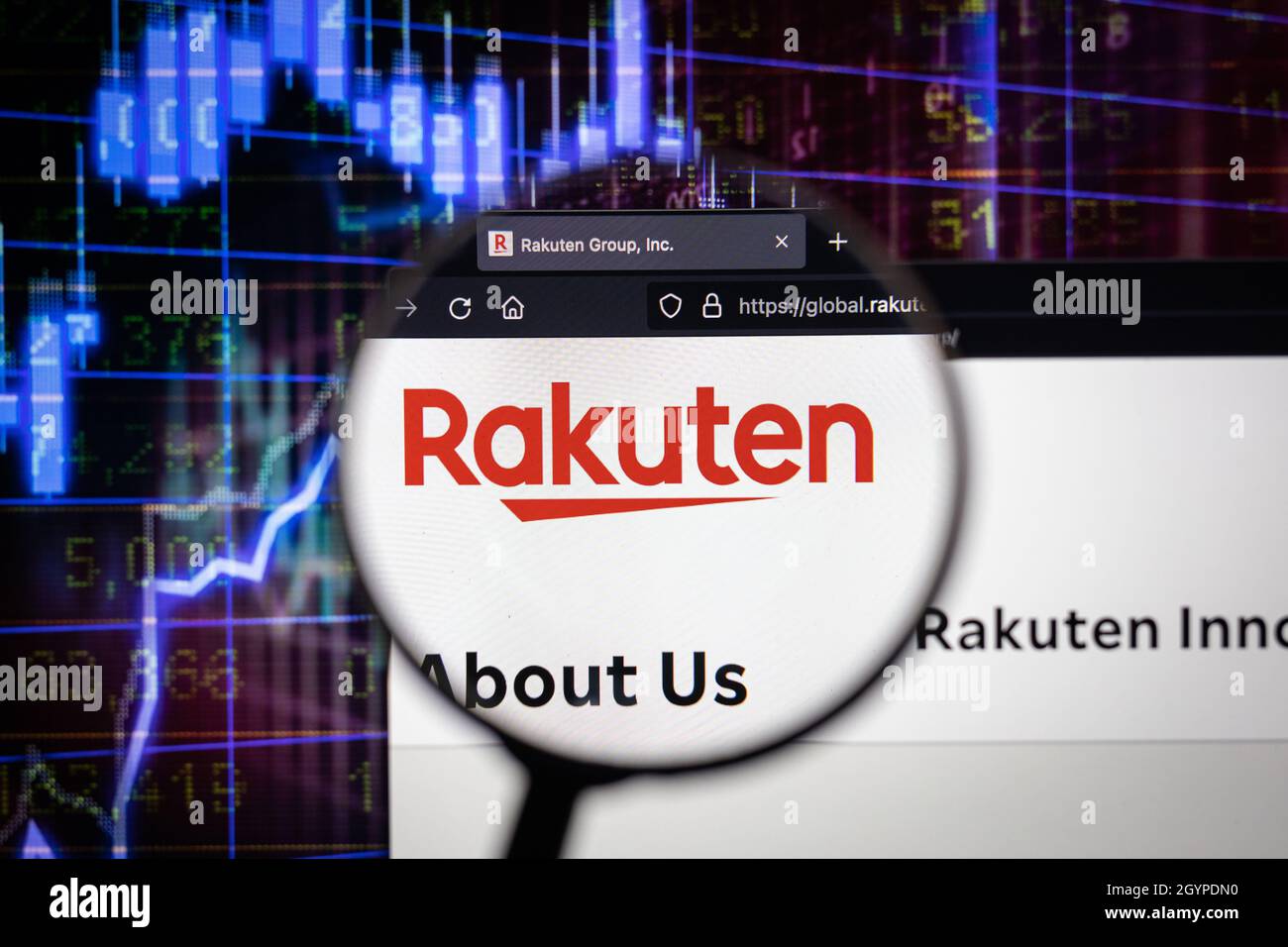 Logo Rakuten azienda su un sito web con blurry di mercato azionario in background, visto su uno schermo del computer attraverso una lente d'ingrandimento. Foto Stock