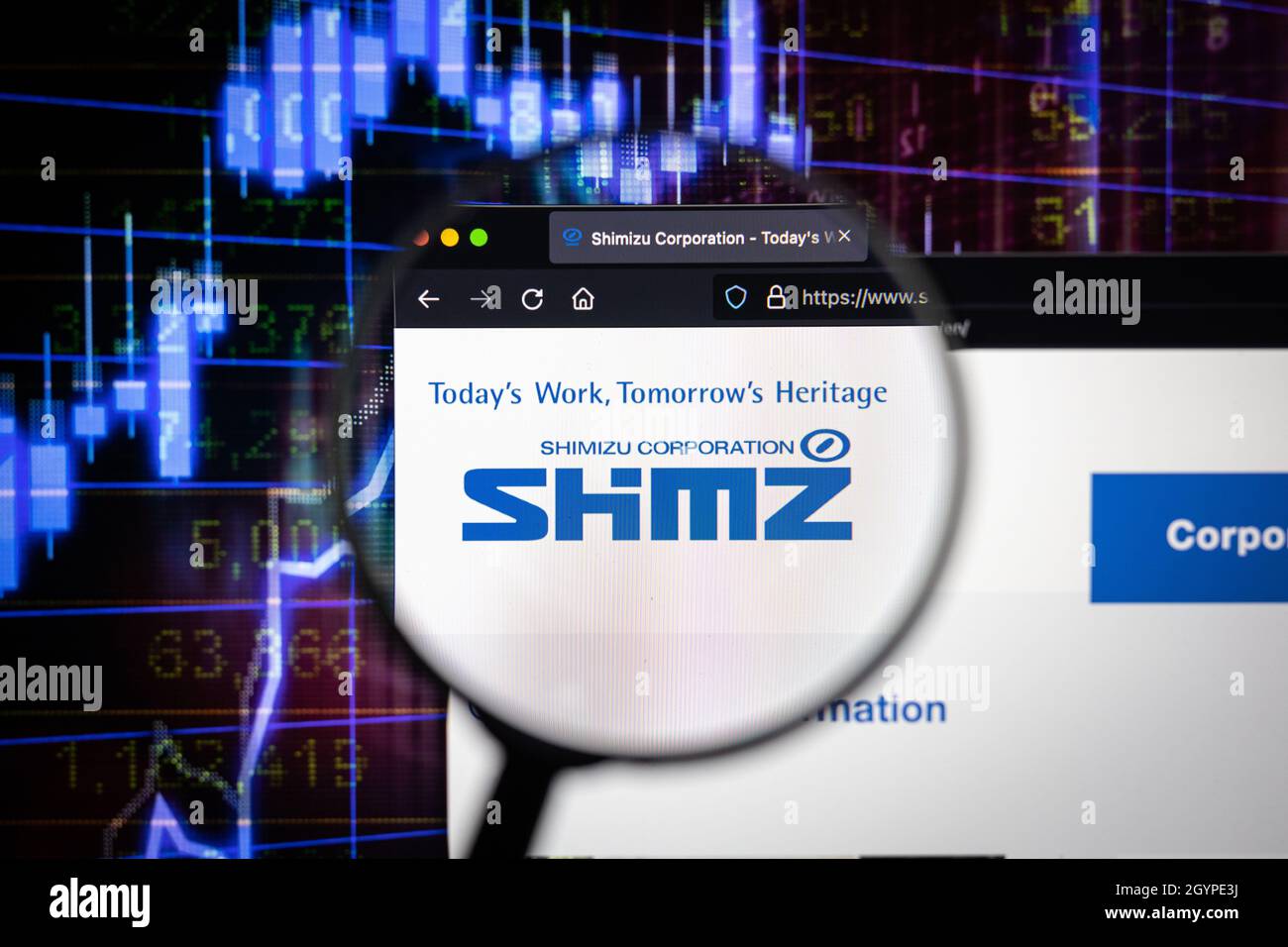 Shimizu Corporation logo azienda su un sito web con blurry borsa grafici in background, visto su uno schermo del computer attraverso una lente d'ingrandimento. Foto Stock