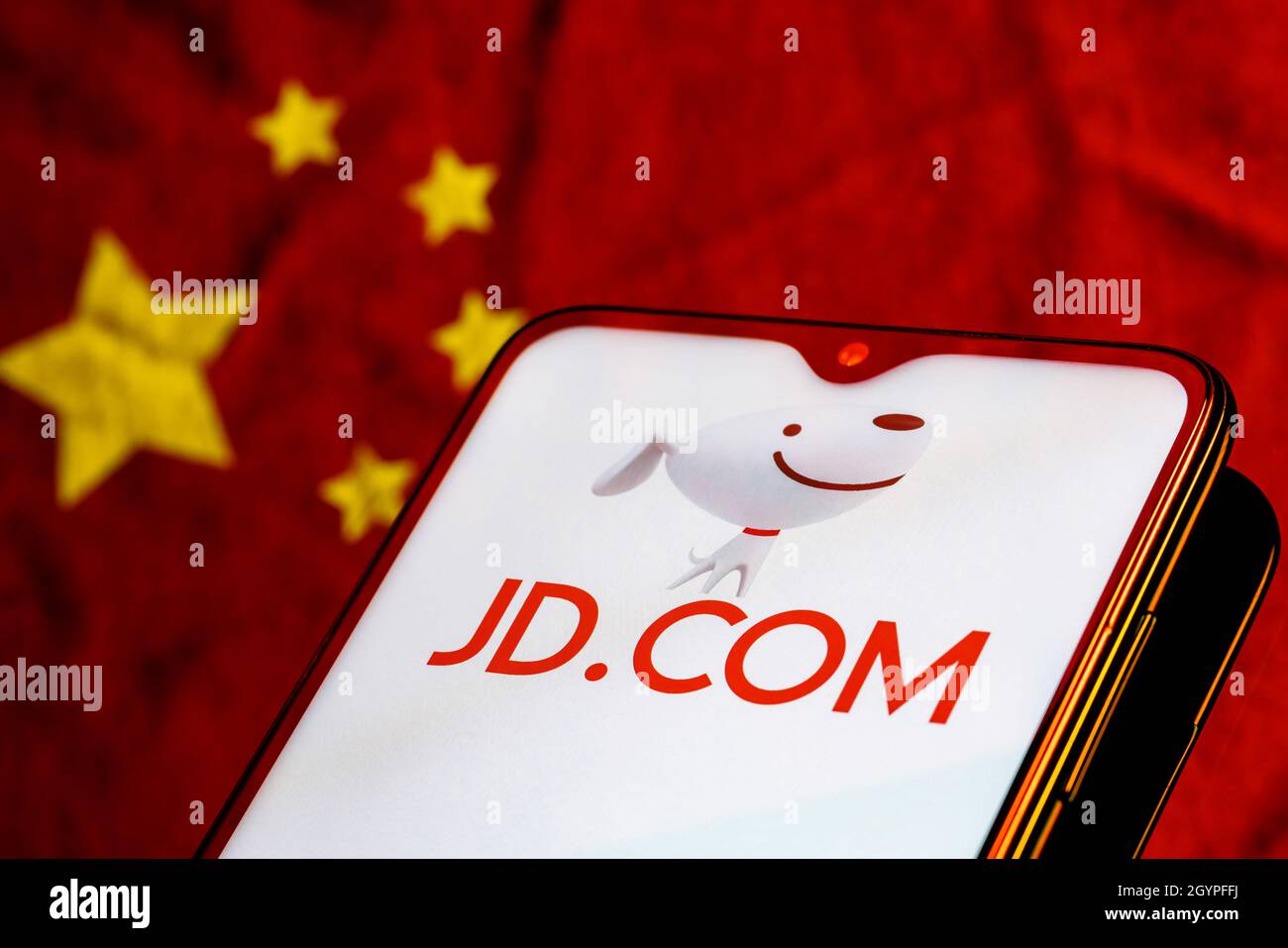 JD.com è una società cinese di e-commerce. Smartphone con il logo JD.com sullo sfondo della bandiera cinese. Foto Stock