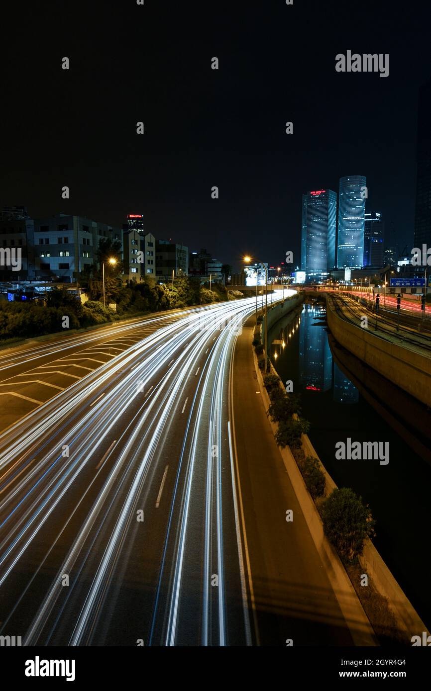 Israele, Tel Aviv, Long Exposure Night shot di Ayalon autostrada con sentieri leggeri. Azrieli alto sorge sullo sfondo Foto Stock