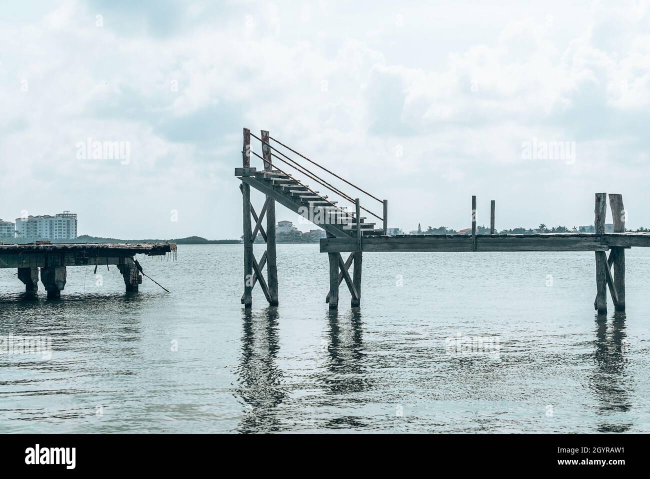 Abbandonato e danneggiato molo di legno sul mare durante il tramonto Foto Stock