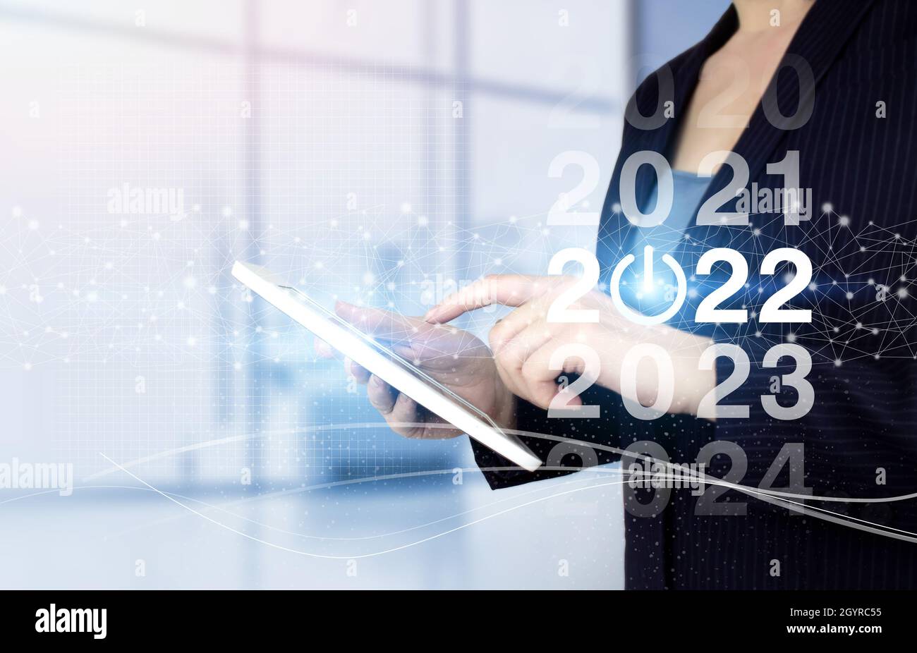 Felice anno nuovo 2022 - mano touch tablet bianco con ologramma digitale 2022 segno su sfondo chiaro sfocato. Nuovo anno 2022,obiettivo,piano,azione. Foto Stock