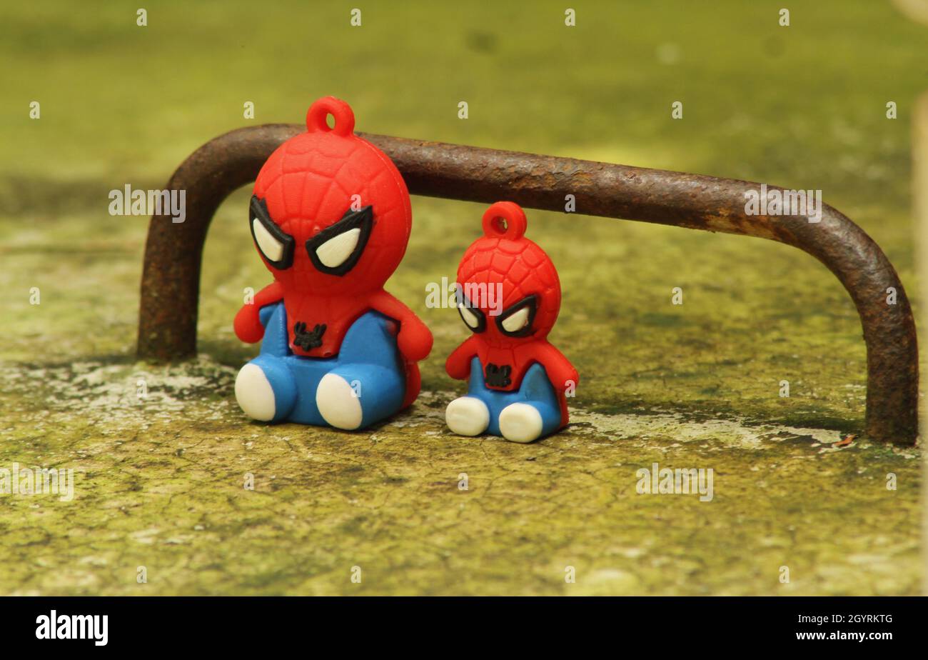 Primo piano di vista di Spiderman giocattolo e Spiderman Jr seduto vicino alla palestra bar Foto Stock