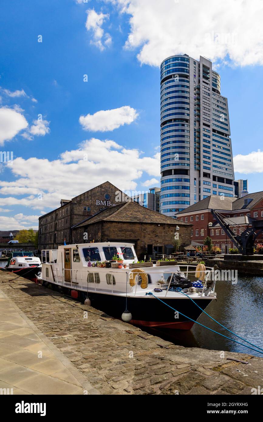 Centro città rigenerato (edifici lungo la riva, uffici Bridgewater Place, ormeggi barche - Leeds Liverpool Canal, Granary Wharf, Yorkshire, Inghilterra Regno Unito. Foto Stock