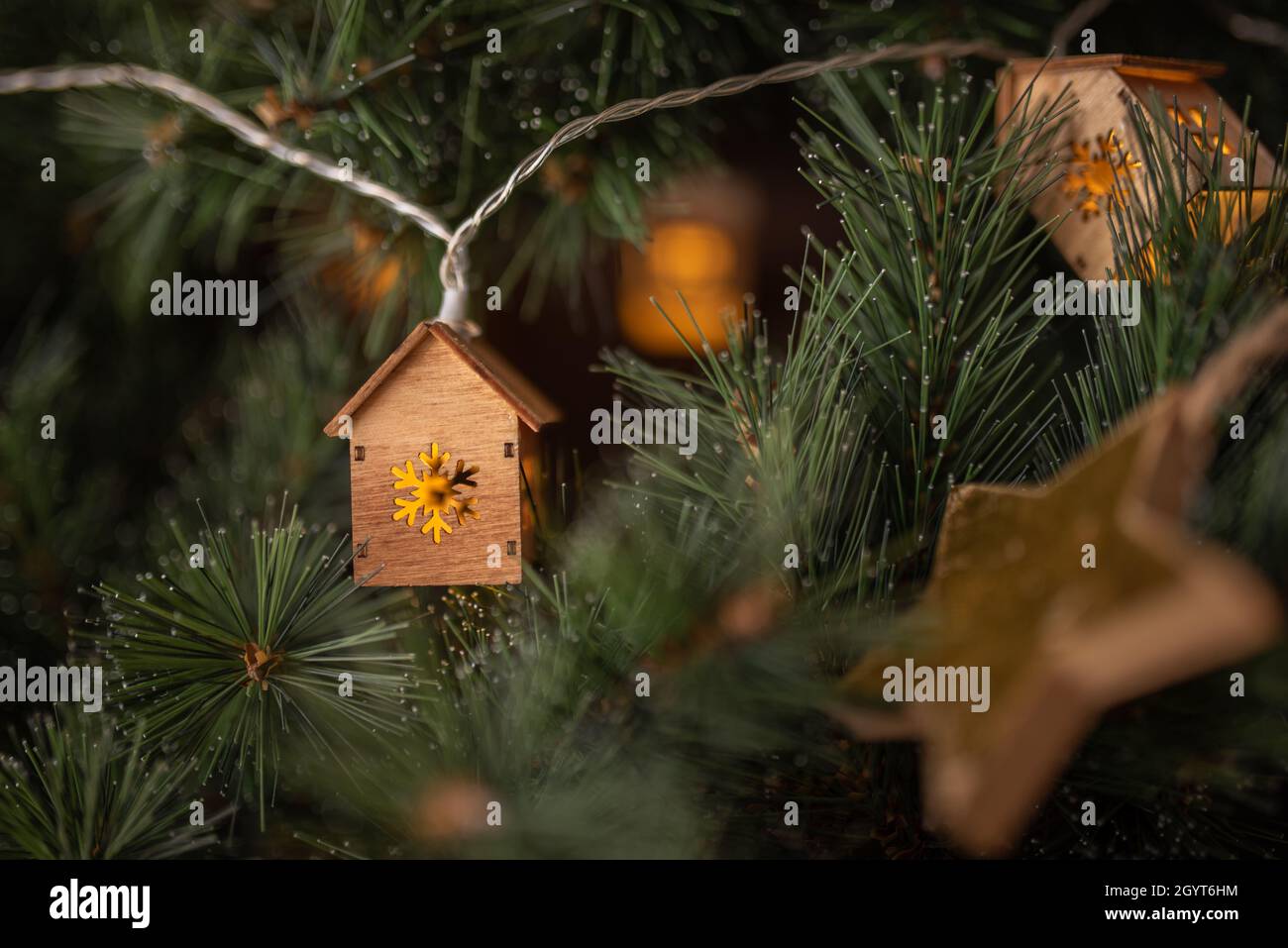 Sfondo orario invernale. Garland in forma di piccole case e stella d'oro. Foto Stock
