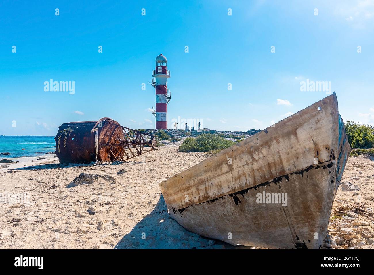 Relitto di boa nautico e barca sulla spiaggia con turista intorno al faro Foto Stock