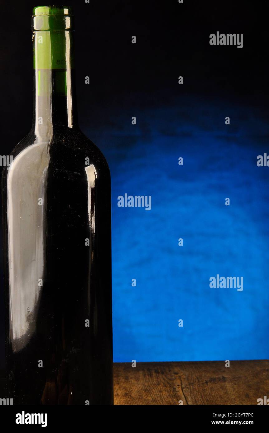 Bottiglia singola di vino con una luce di sfondo blu Foto Stock
