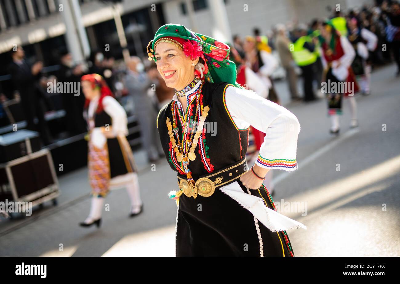 Stoccarda, Germania. 9 ottobre 2021. Per celebrare il 200° anniversario della Rivoluzione greca nel 1821, le donne in abito tradizionale camminano in una parata commemorativa e onoraria, allietata da decine di spettatori. Credit: Christoph Schmidt/dpa/Alamy Live News Foto Stock