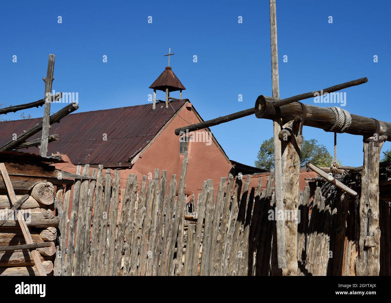 Una croce cristiana in cima a una storica cappella in adobe a El Rancho de las Golondrinas complesso di storia vivente vicino a Santa Fe, New Mexico. Foto Stock