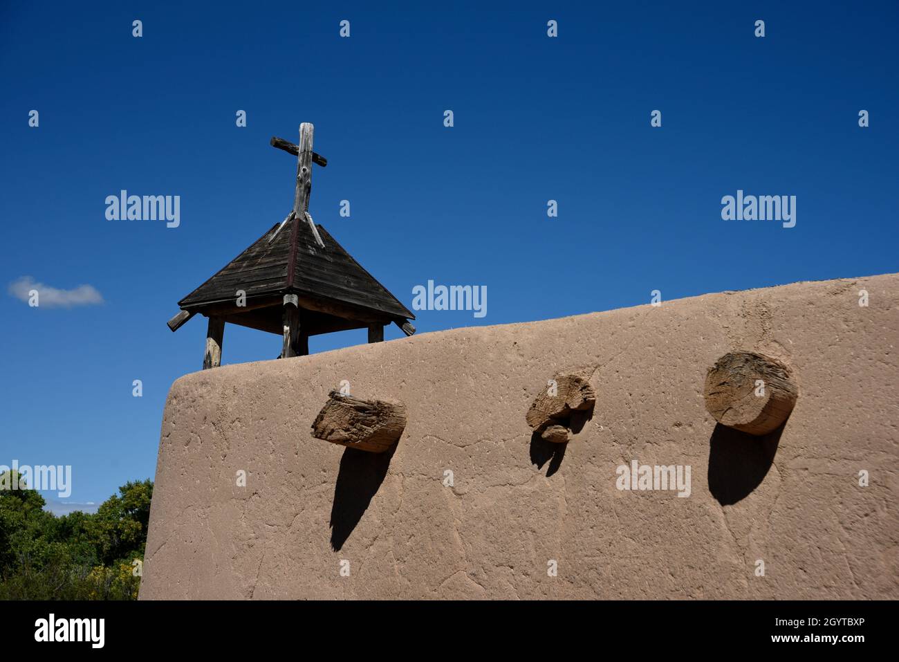 Una croce cristiana in cima a una storica cappella in adobe a El Rancho de las Golondrinas complesso di storia vivente vicino a Santa Fe, New Mexico. Foto Stock