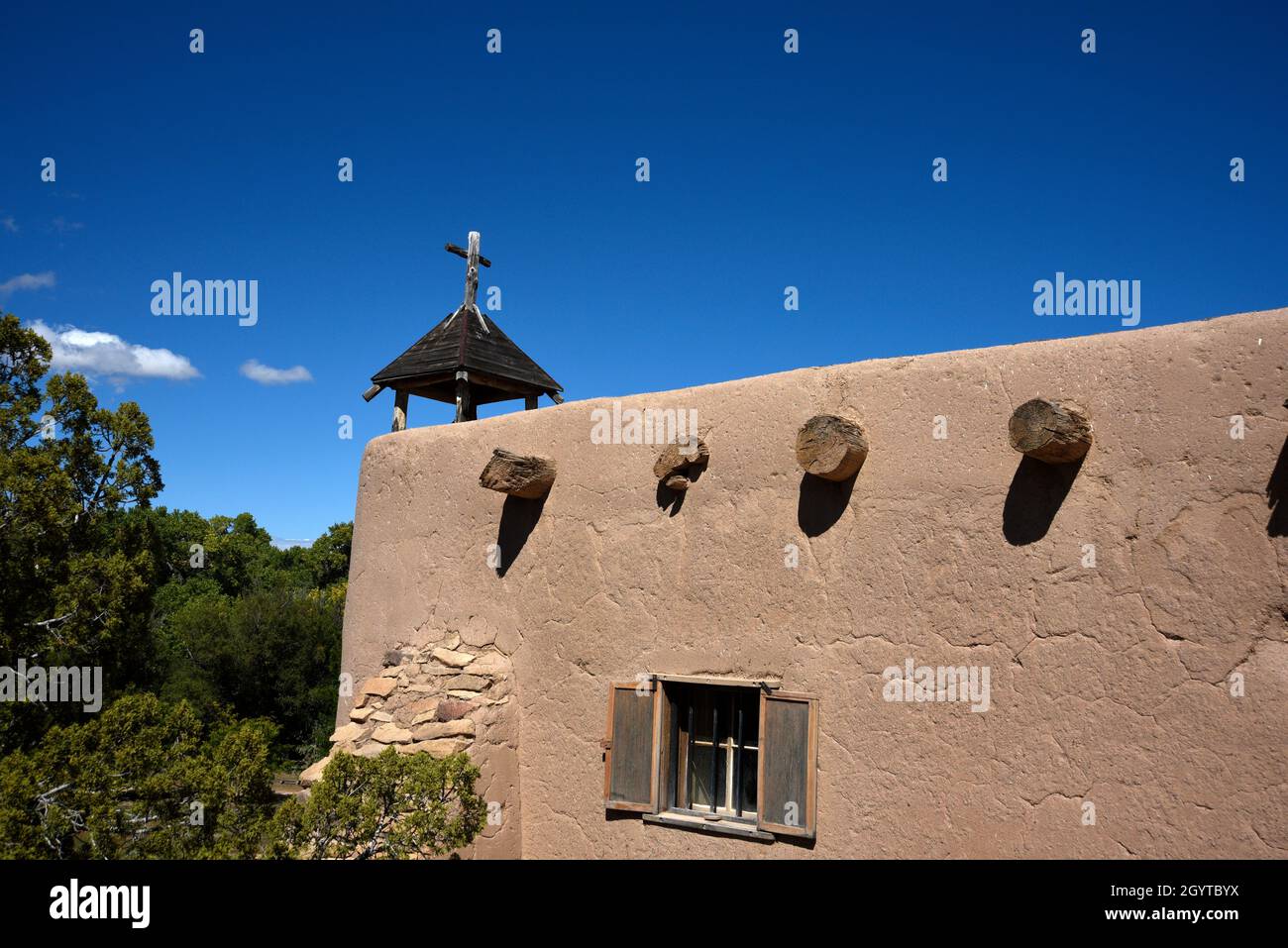 Una croce cristiana in cima a una storica cappella in adobe a El Rancho de las Golondrinas complesso di storia vivente vicino a Santa Fe, New Mexico. Foto Stock