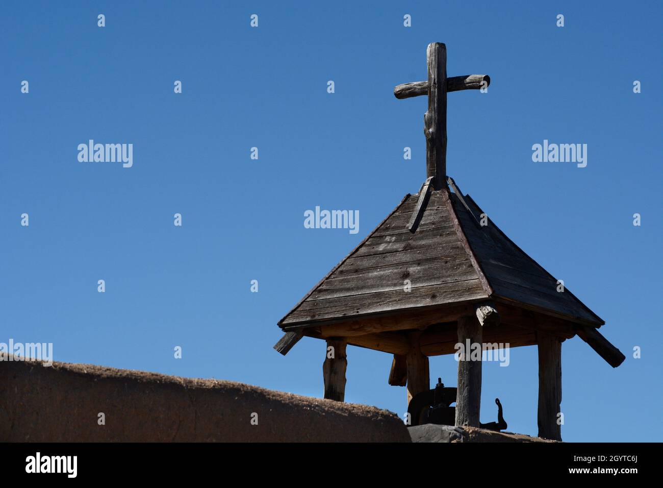 Una croce cristiana in cima a una storica cappella in adobe a El Rancho de las Golondrinas complesso di storia vivente vicino a Santa Fe, New Mexico. Foto Stock