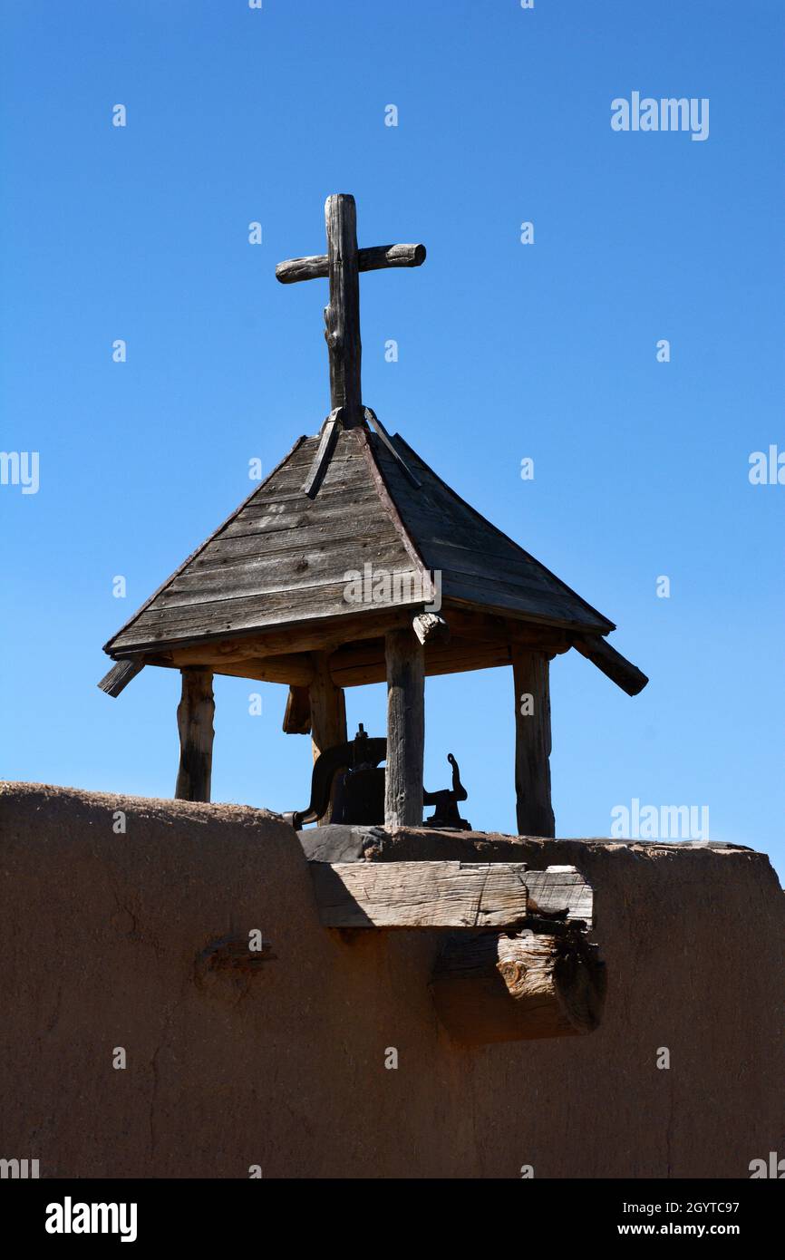 Una croce cristiana in cima a una storica cappella in adobe a El Rancho de las Golondrinas complesso di storia vivente vicino a Santa Fe, New Mexico. Foto Stock