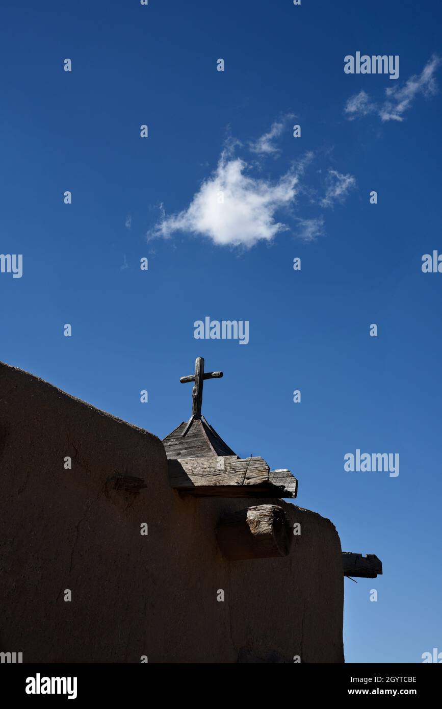 Una croce cristiana in cima a una storica cappella in adobe a El Rancho de las Golondrinas complesso di storia vivente vicino a Santa Fe, New Mexico. Foto Stock