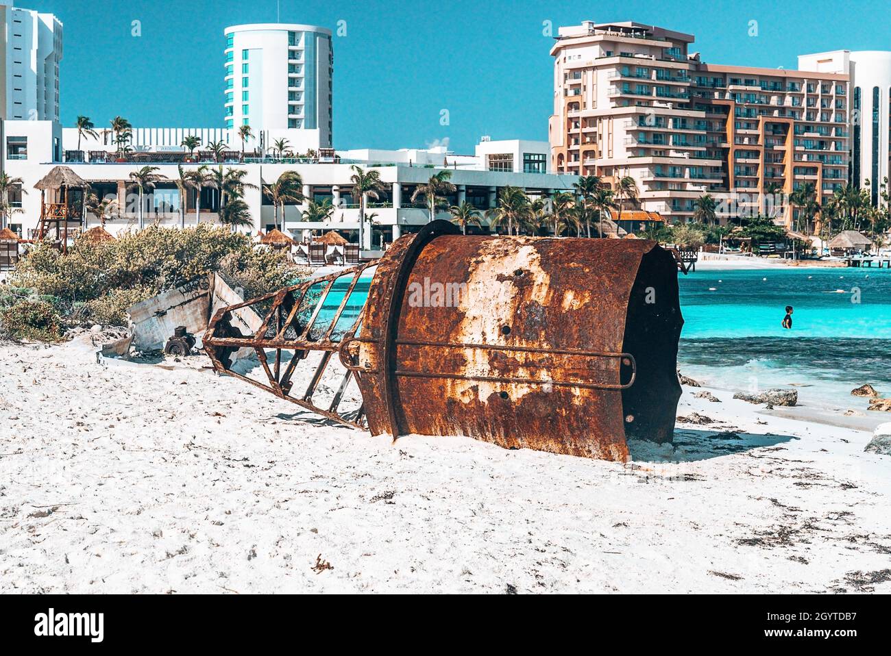 Relitto di boa nautico sulla spiaggia con hotel di lusso sullo sfondo Foto Stock